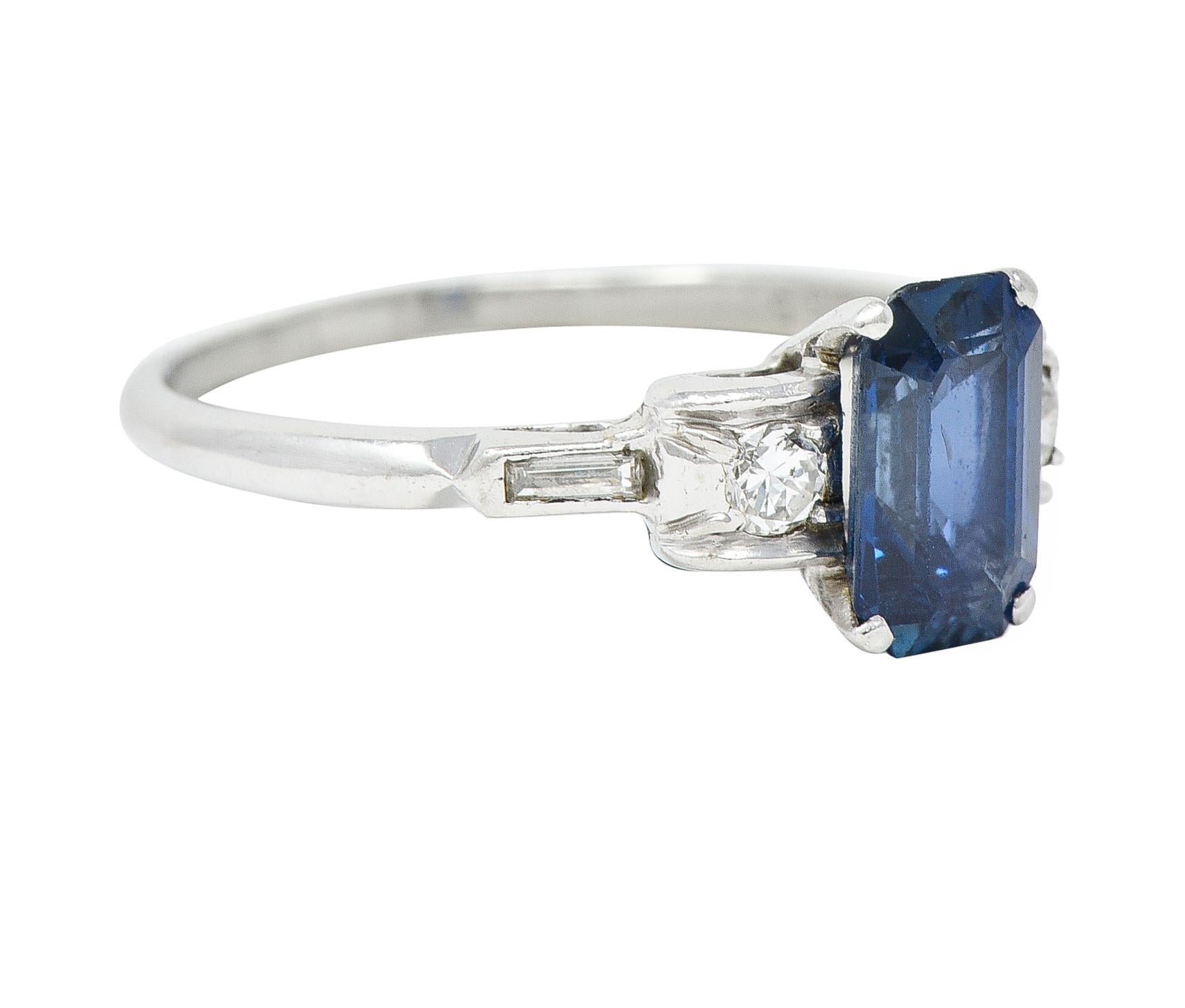 Centering an emerald cut sapphire weighing approximately 1.51 carats total - transparent medium blue
Prong set in a basket and flanked by arching cathedral shoulders with flush set diamonds
Old European and baguette cut - weighing approximately 0.16