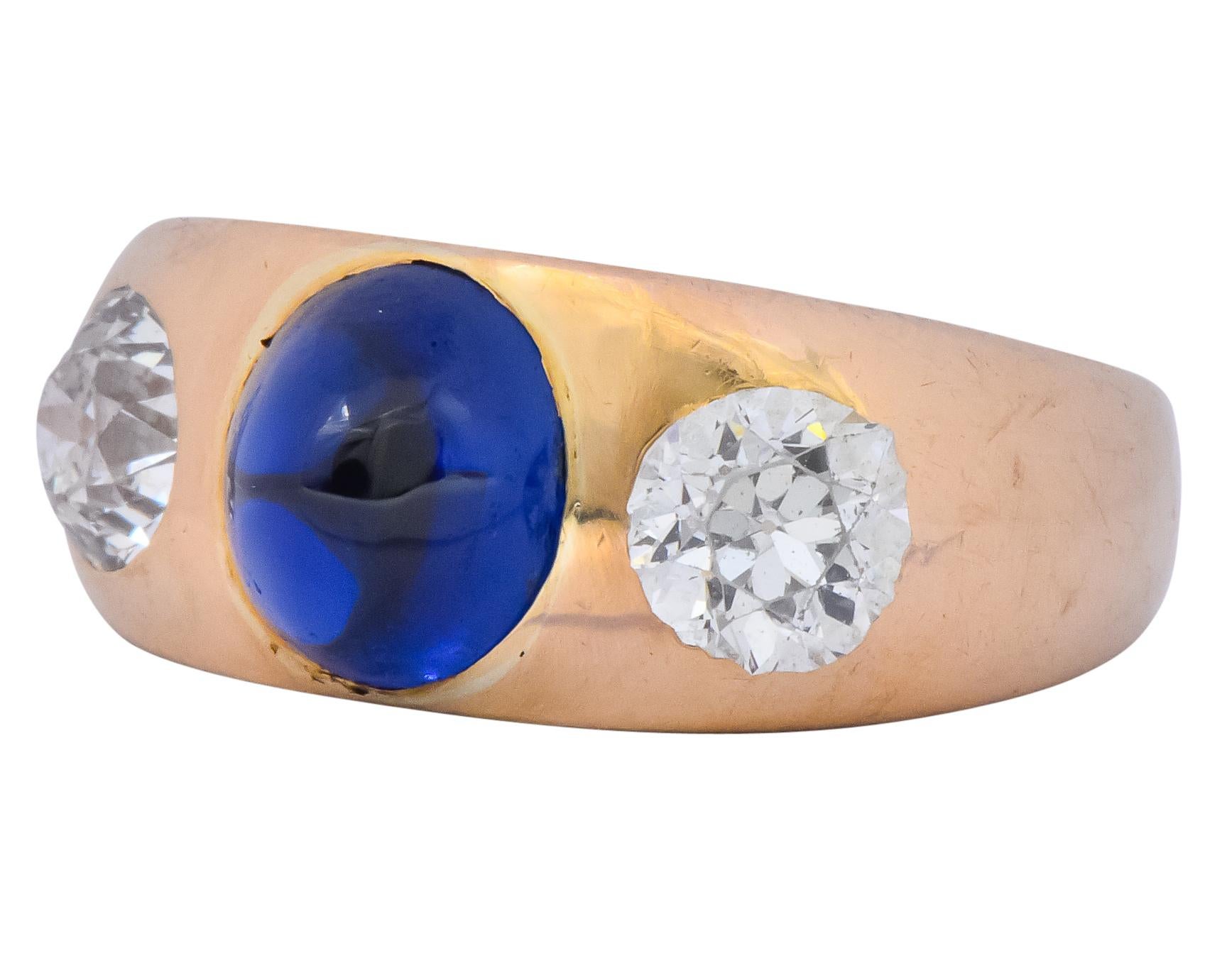 Centering an oval cabochon sapphire weighing approximately 2.10 carats, transparent blue color with no indications of heat treatment

Flanked by two old European cut diamonds weighing approximately 1.30 carats total, H/I in color and VS