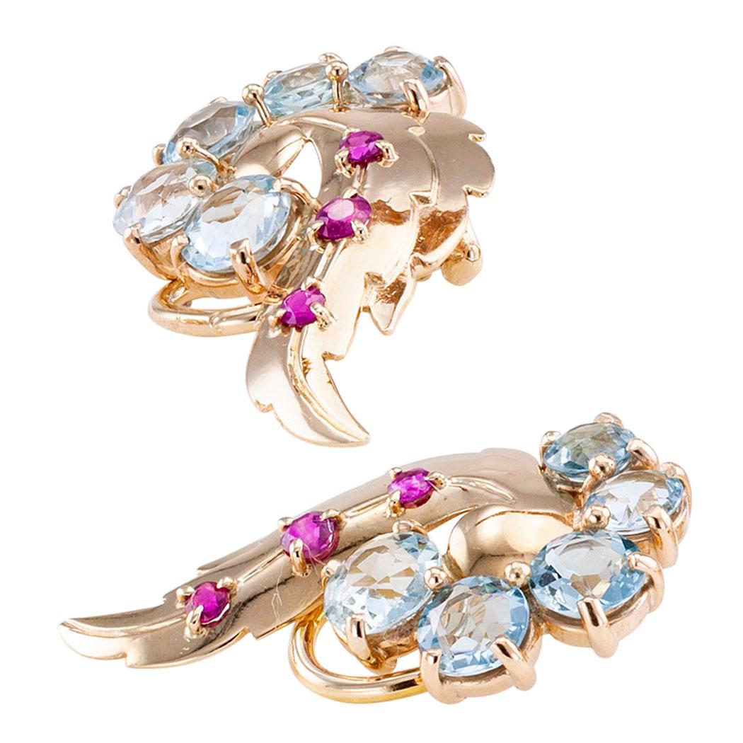 Bailey Banks & Biddle Retro aquamarine ruby and gold clip on earrings circa 1940. The matching, stylized wing-shaped designs feature trios of small round rubies underscored by slightly graduated similarly cut aquamarines totaling approximately 4.00