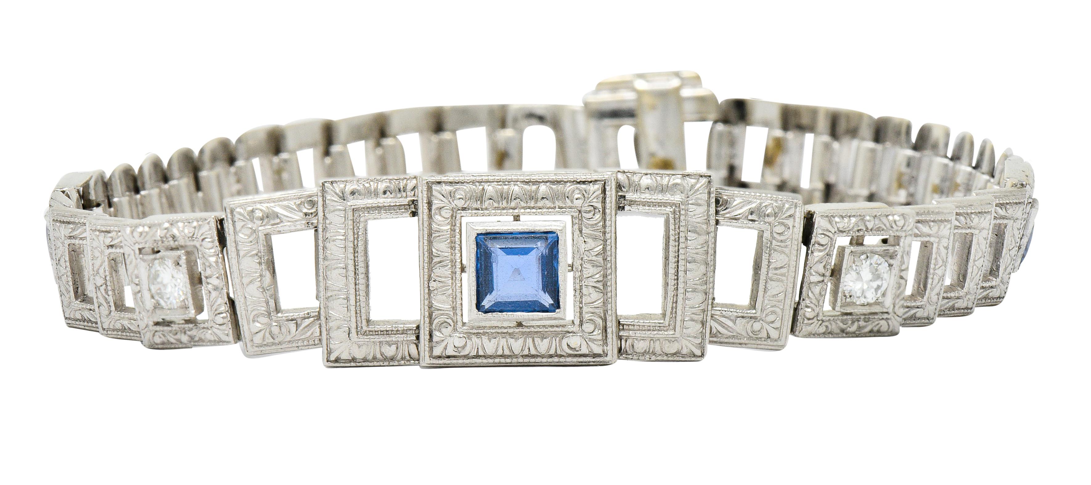 Link style bracelet comprised of cascading square links, deeply engraved

Centering three square step cut sapphire weighing approximately 1.10 carats total

Transparent with well-matched cornflower blue color

Accented by two round brilliant cut