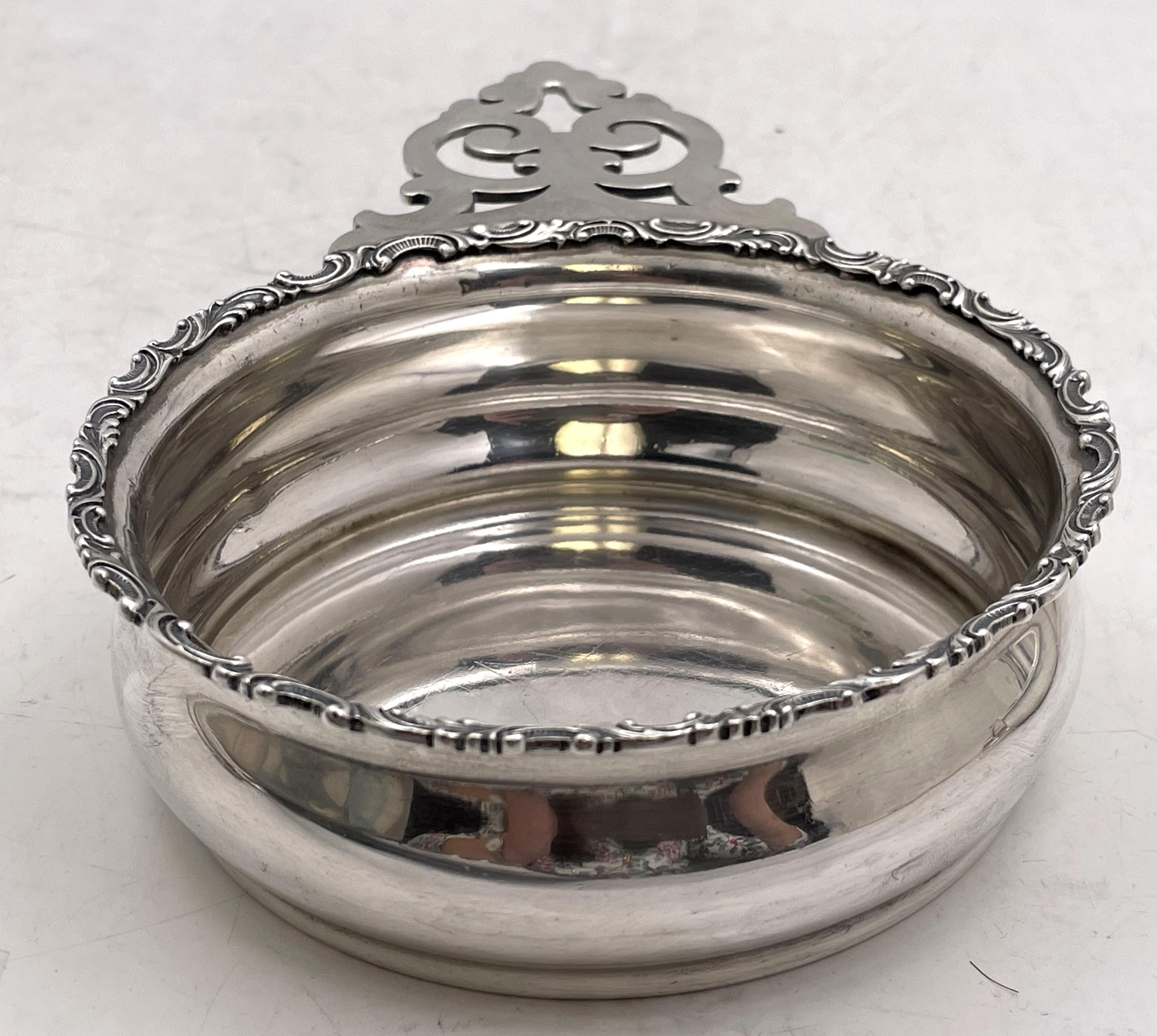 Cuenco porringer Bailey, Banks & Biddle de plata de ley, con asa calada y motivos curvilíneos adornando el borde. Mide 7 3/8'' de profundidad por 4 3/4'' de diámetro y 1 1/2'' de altura, pesa 6,7 onzas troy y lleva los sellos que se muestran.

Está