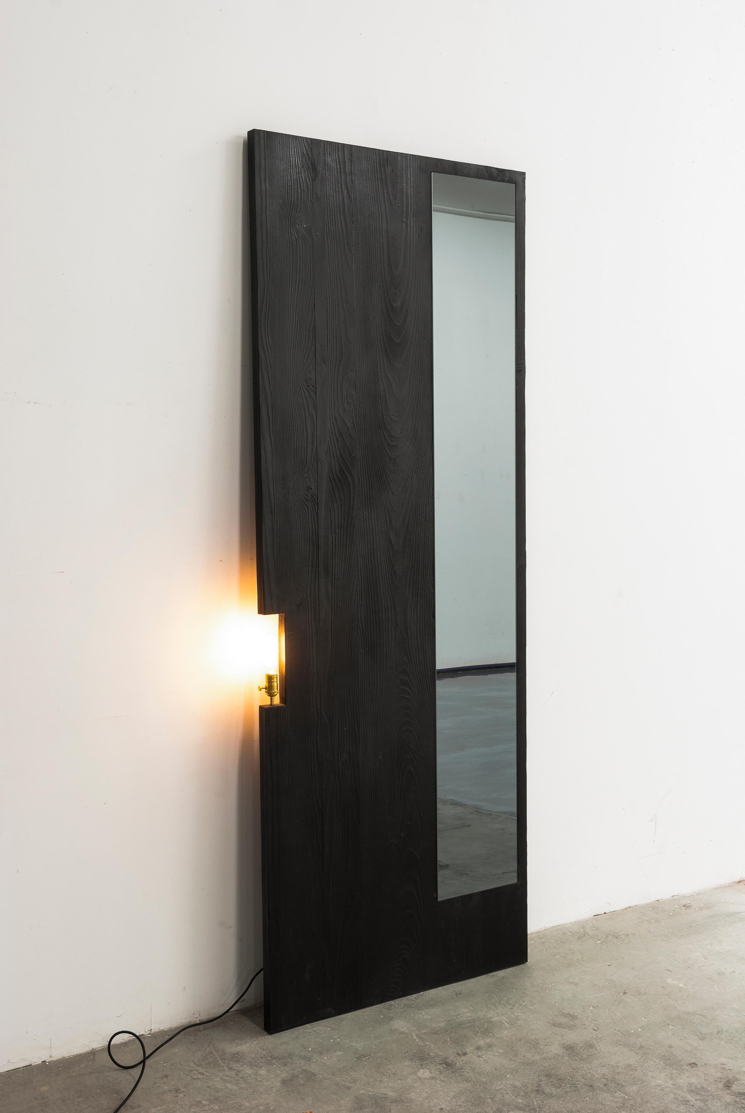 This full size mirror by Bailey Fontaine functions as both a mirror and a floor lamp. The Char Mirror is a utilitarian and practical sculpture piece for your space, and at the same time fulfills a sculptural aesthetic. As an emerging furniture