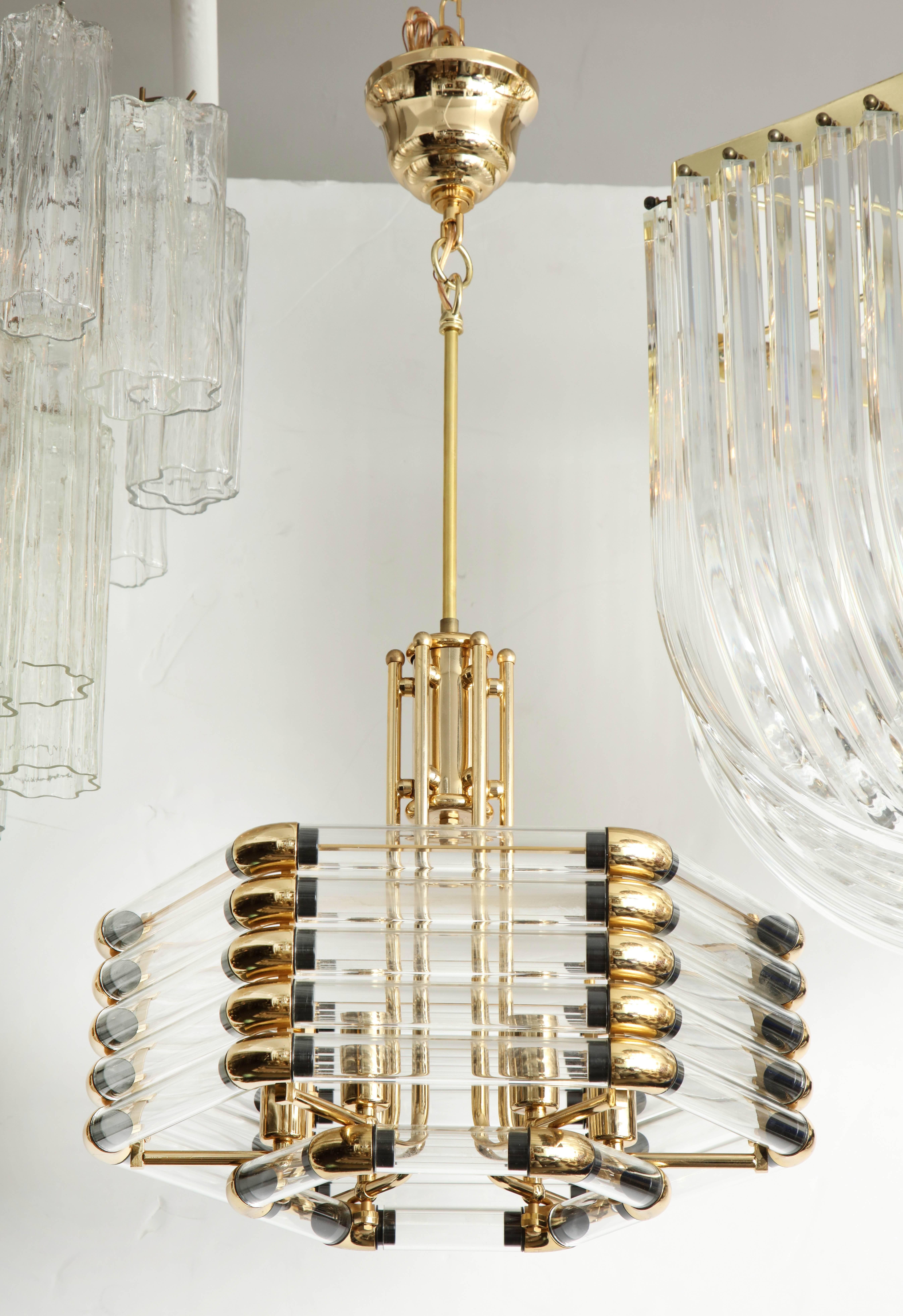 A beautiful glass and brass chandelier by Bakalowits and Sohne.
The hexagonal chandelier frame has clear glass tubes which are held by polished brass appointments, the fixture is illuminated by six-light sources that have been newly rewired for the