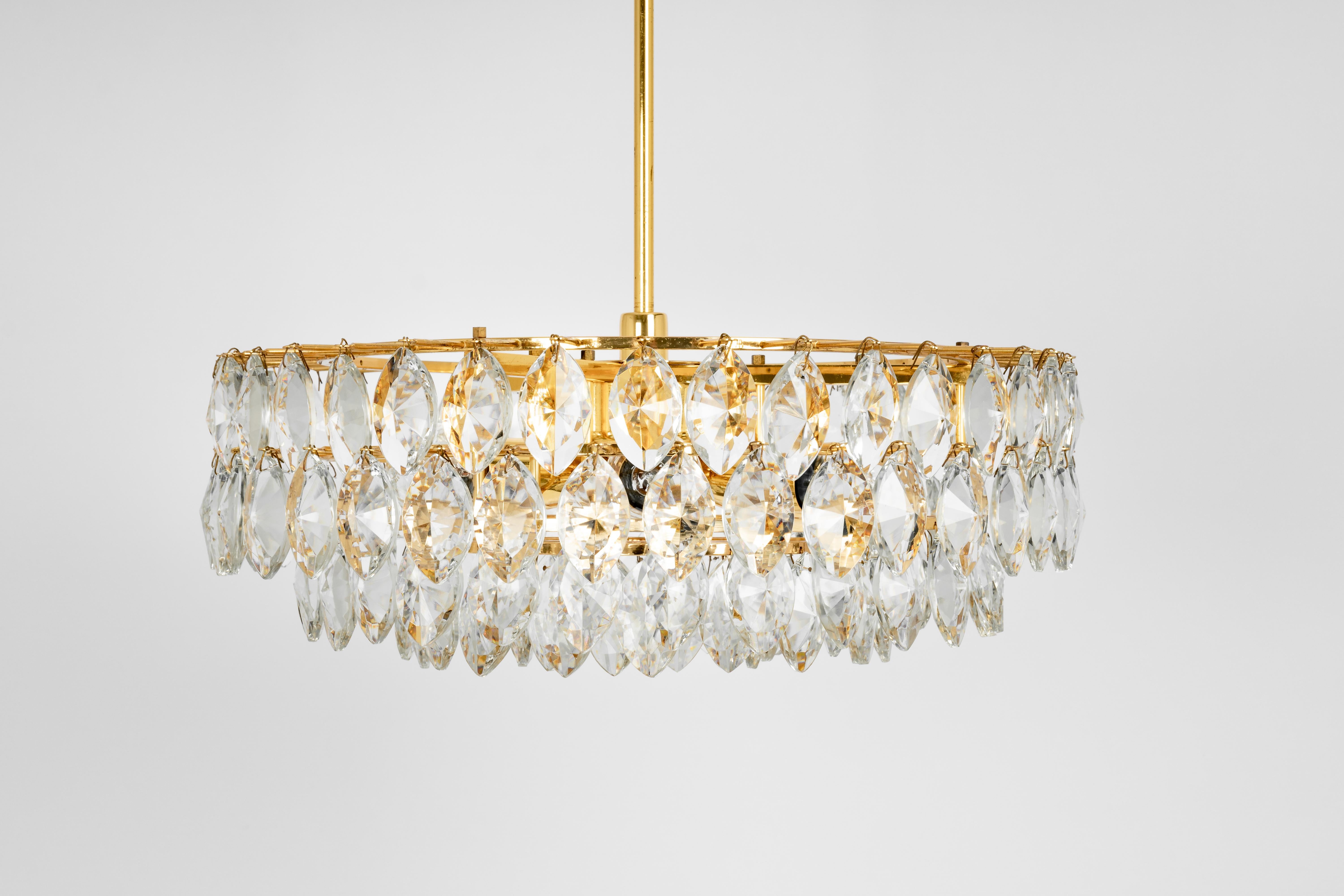A stunning five-tier chandelier by Bakalowits & Sohne, Austria, manufactured in circa 1960-1969. A handmade and high quality piece. The ceiling fixture and the frame are made of gilt brass and have five rings with lots of facetted crystal glass