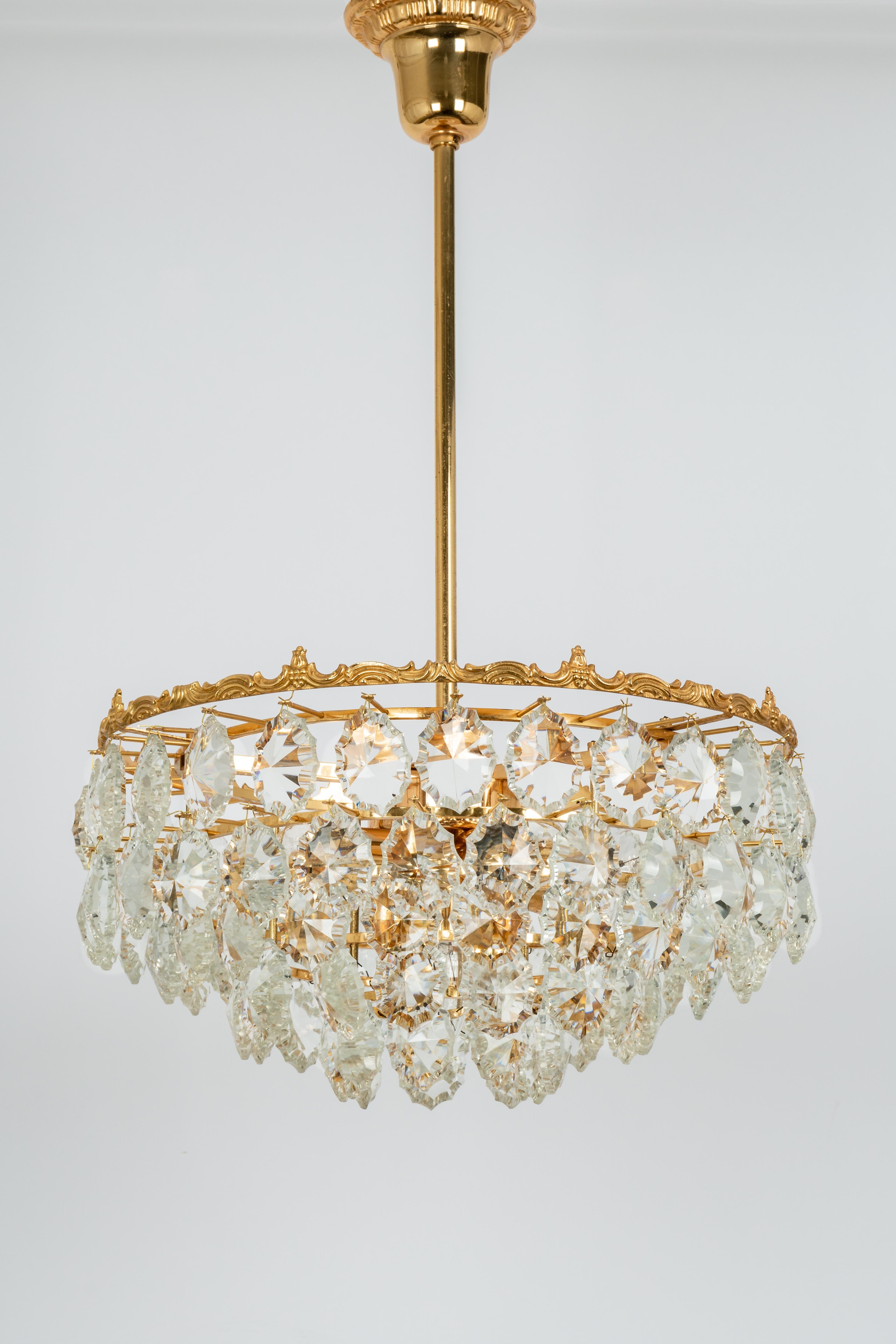 A stunning five-tier chandelier by Bakalowits & Sohne, Austria, manufactured in circa 1960-1969. A handmade and high quality piece. The ceiling fixture and the frame are made of gilt brass and has six rings with lots of facetted crystal glass