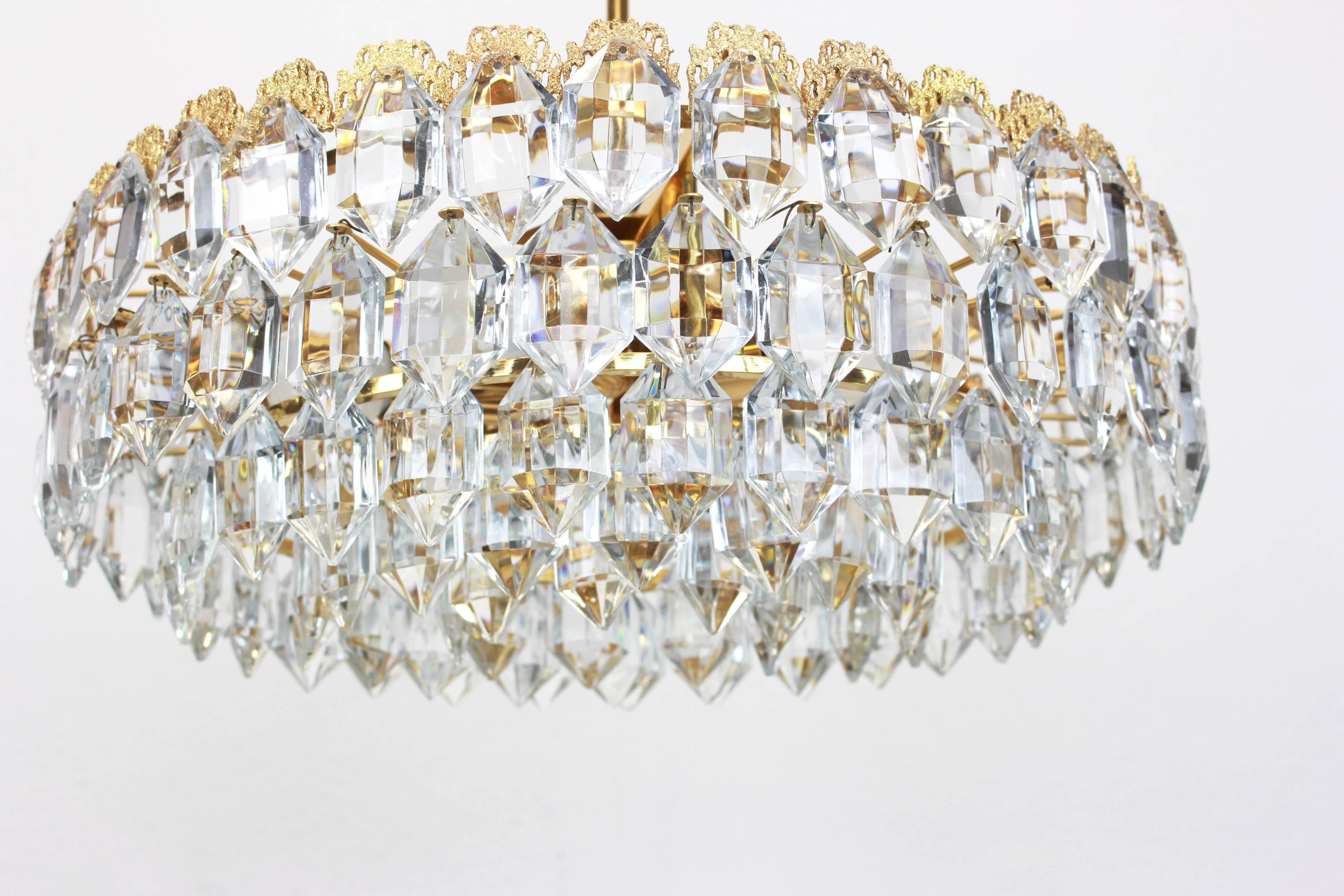 A stunning five-tier chandelier by Bakalowits & Sohne, Austria, manufactured in circa 1960-1969. A handmade and high quality piece. The ceiling fixture and the frame are made of gilt brass and have five rings with lots of facetted crystal glass