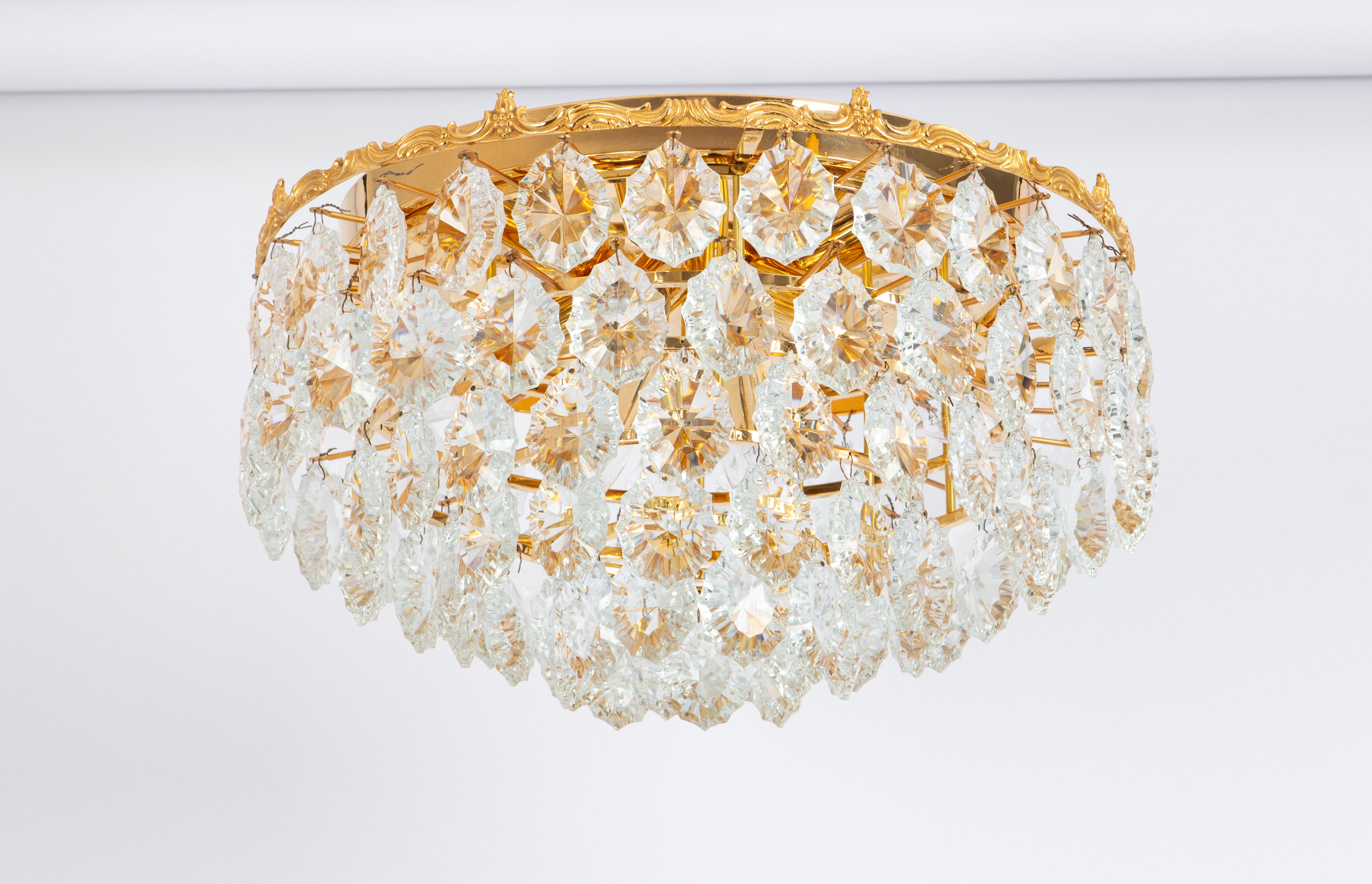 A stunning six-tier Flush mount by Bakalowits & Sohne, Austria, manufactured in circa 1960-1969. A handmade and high-quality piece. The ceiling fixture and the frame are made of gilt brass and have rings with lots of facetted crystal glass elements.