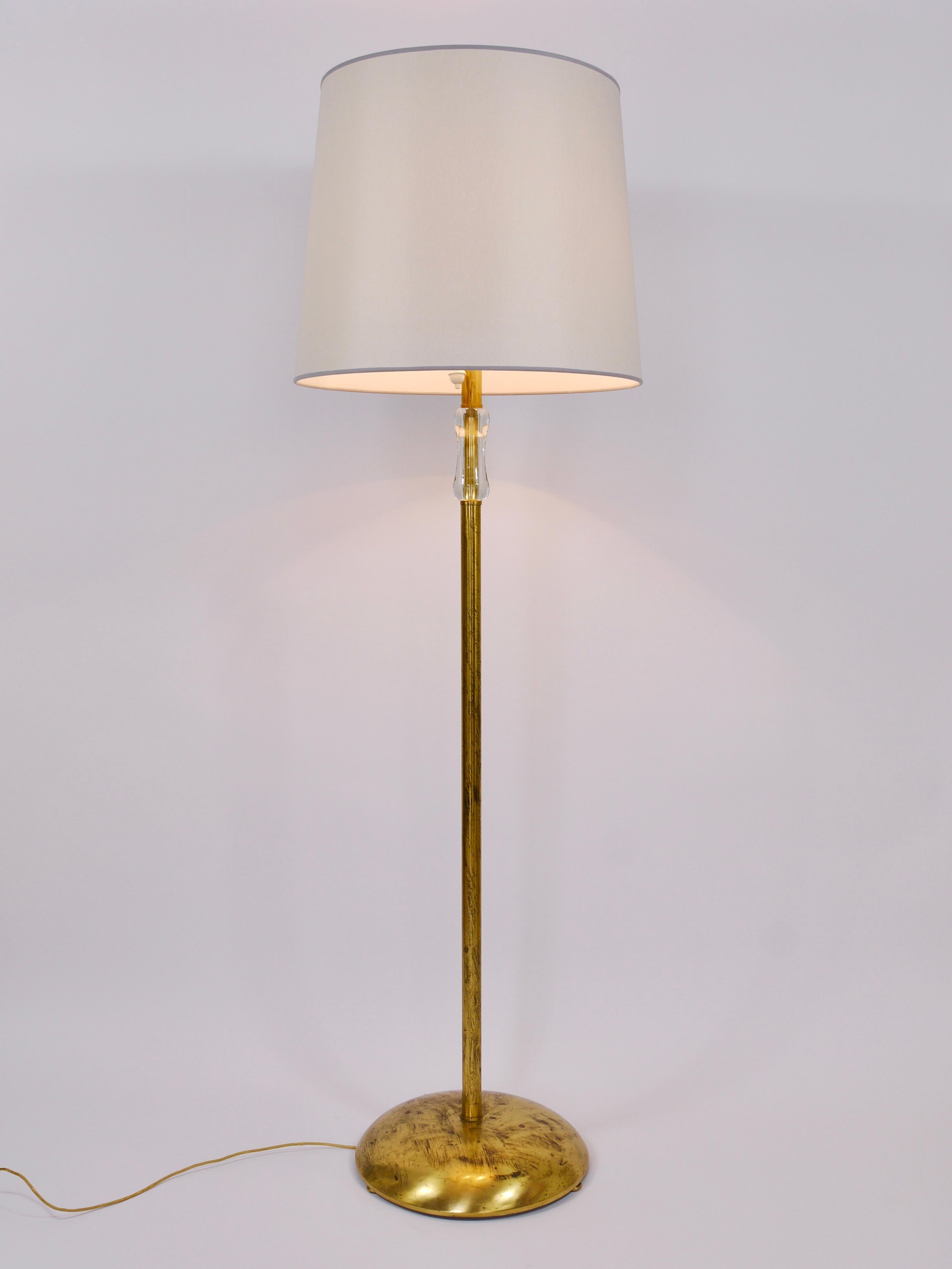 Una monumental y elegante lámpara de pie de latón de mediados de siglo de la década de 1950, diseñada y ejecutada por Bakalowits & Söhne en Viena, Austria. Hecha a mano por expertos en latón, esta lámpara  tiene una pantalla de 20 pulgadas de