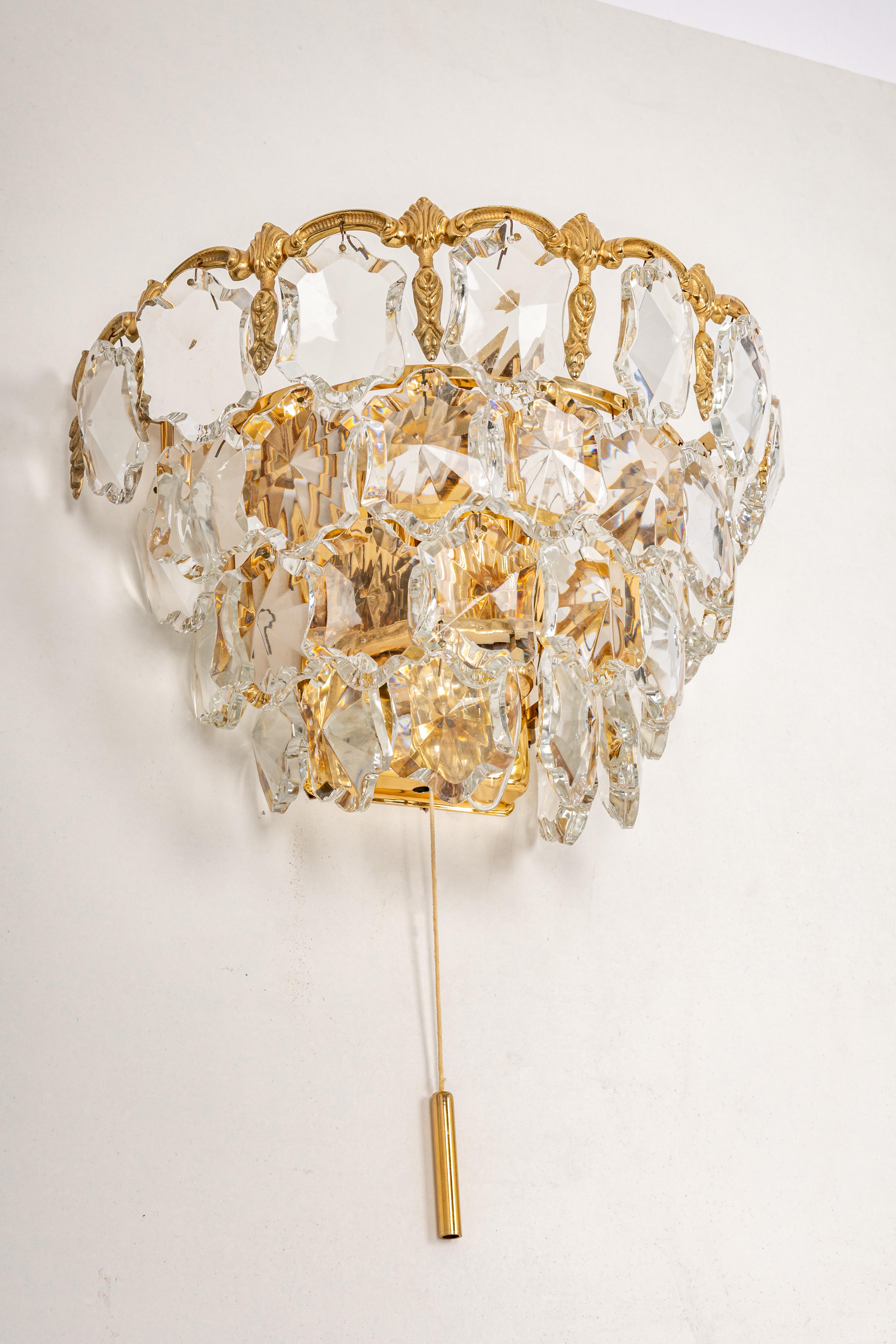A pair of stunning wall lights made by Bakalowits, Austria, manufactured in circa 1960-1969. A handmade and high quality piece. The frame is made of gilt brass and has 4 tiers with lots of facetted crystal glass elements. 

Sockets: 3 x E14