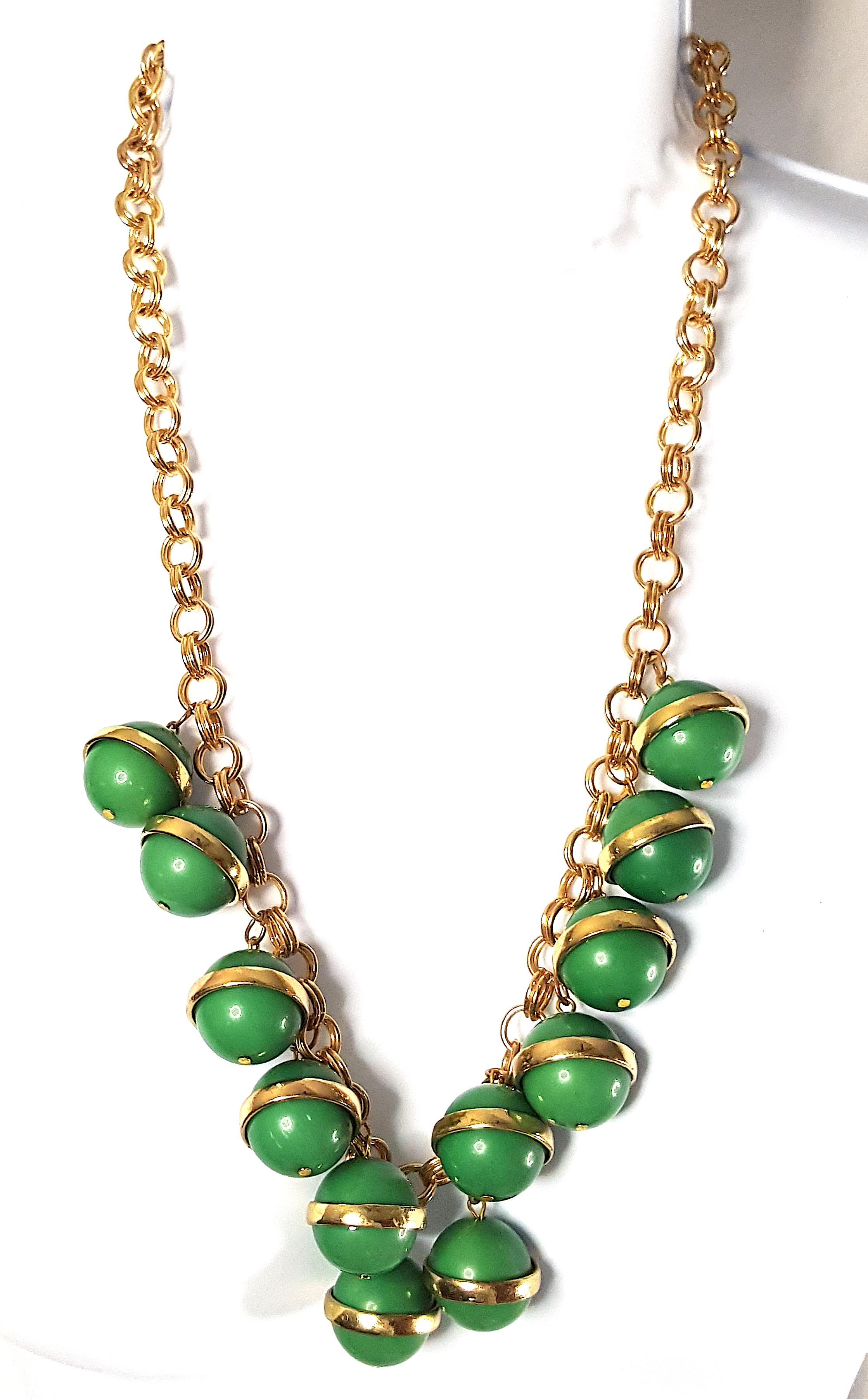 Most likely made in Germany during the Art Deco period, this vintage unsigned long heavy 12-pendant gold-gilt chain-link bib necklace features ball charms of gold-ringed emerald-green matte Bakelite. Hanging 13-inches from the back of the neck, the