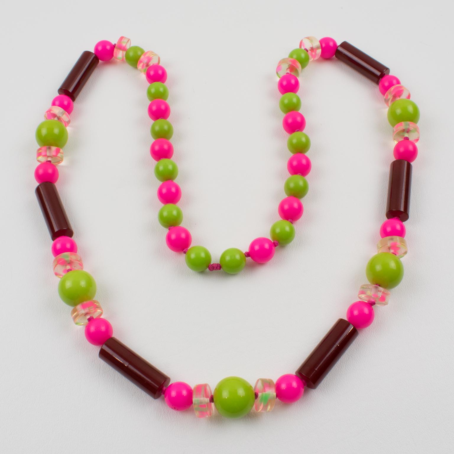 This is a beautiful extra-long Bakelite and Lucite beaded necklace. The piece boasts assorted beads in various shapes: round, long stick, and round disk, some with a pattern. Stunning mix-and-match flashy colors, apple green marble, hot pink, and