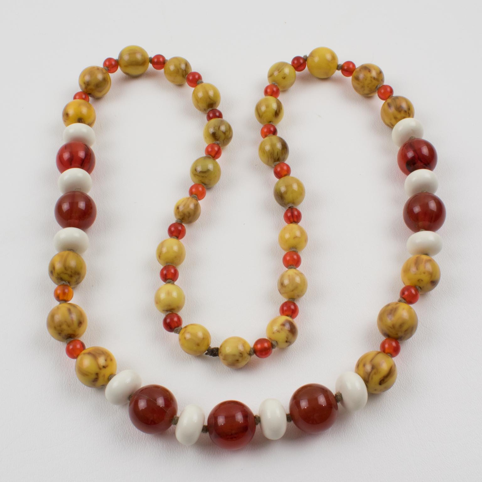 Ce superbe collier de perles extra-long comporte des perles en bakélite et en lucite de formes rondes et tomates assorties. Le mélange et l'assortiment des couleurs automnales s'enorgueillissent du marbre de la bière de racine, du thé rouge