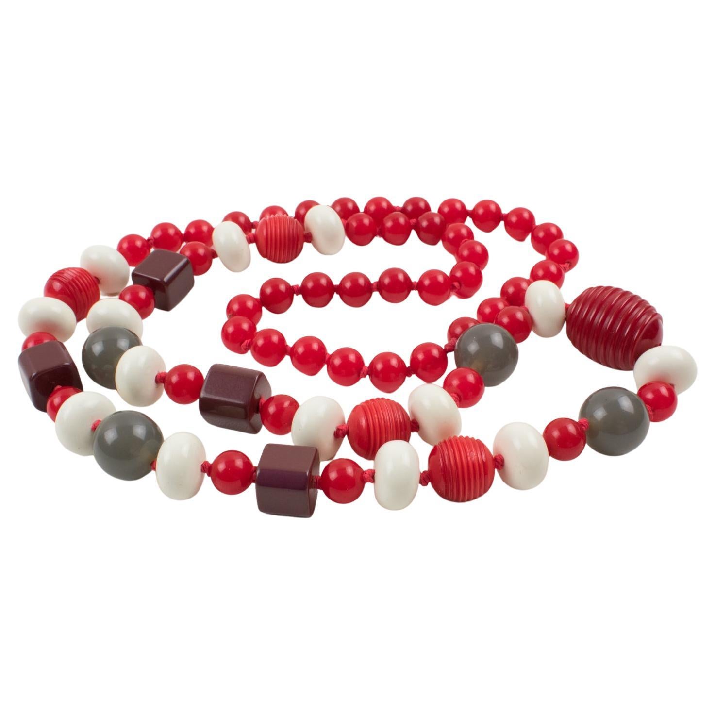 This stunning extra-long Bakelite and Lucite beaded necklace features assorted beads in various shapes: round, tomato, little square, and oval, some with carving. The matching chic colors, magenta red, purple plum, and mouse gray are contrasted with