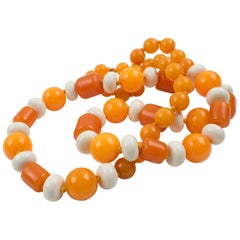 Collier long en bakélite et Lucite de couleurs orange et blanches