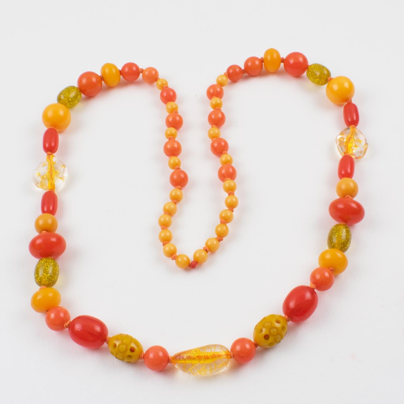 Colorful extra-long Bakelite and Lucite necklace. Assorted beads in various carved shapes: round, tomato, and oval, some with carving, and some with a pattern. Mix and match bright sunny colors in assorted tones of butterscotch, yellow saffron,