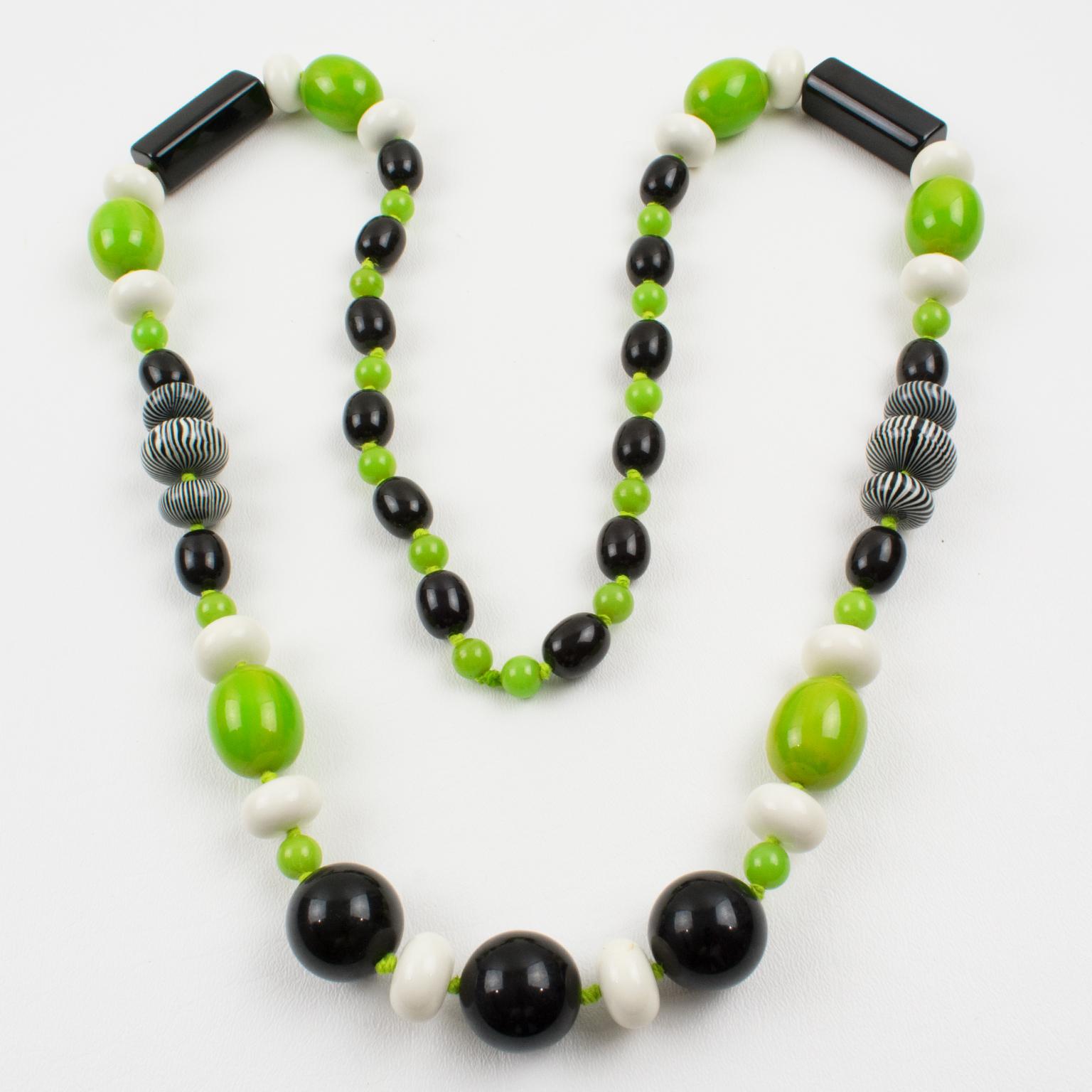 Charming extra-long Bakelite and Lucite beaded necklace. Assorted beads in various shapes: round, tomato, long stick, and oval, some with a pattern. Mix and match fancy colors, apple green marble, true licorice black contrasted with white Lucite