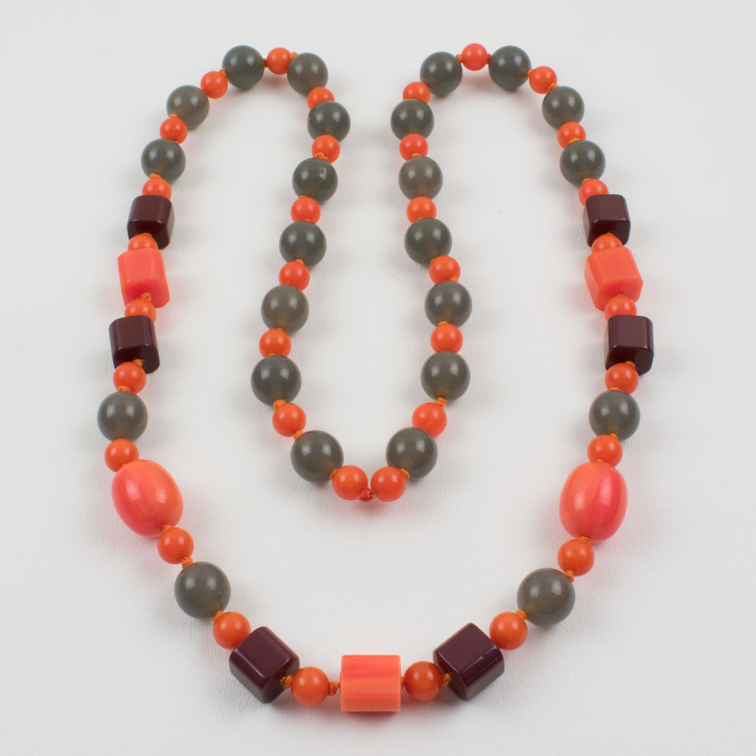 Exquisite extra-long Bakelite and Lucite beaded necklace. Assorted beads in various shapes: round, little square, and oval. Elegant mix and match colors, tequila pink marble, purple plum, and tangerine orange contrasted with mouse gray Lucite beads.