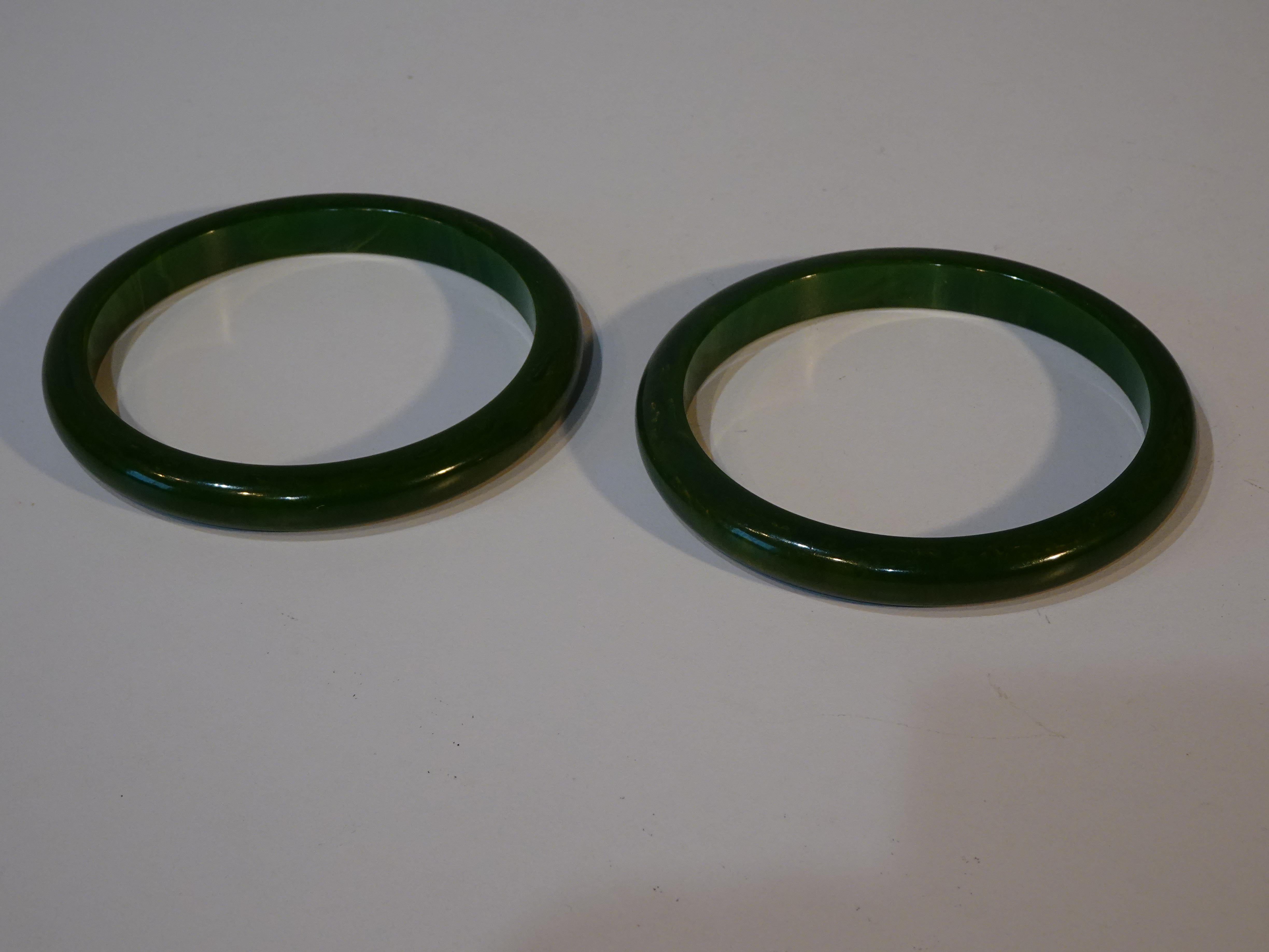 A collection of five Bakelite bangle bracelets two are in a jade green marbleized tone 3' dia. outside x 1/4