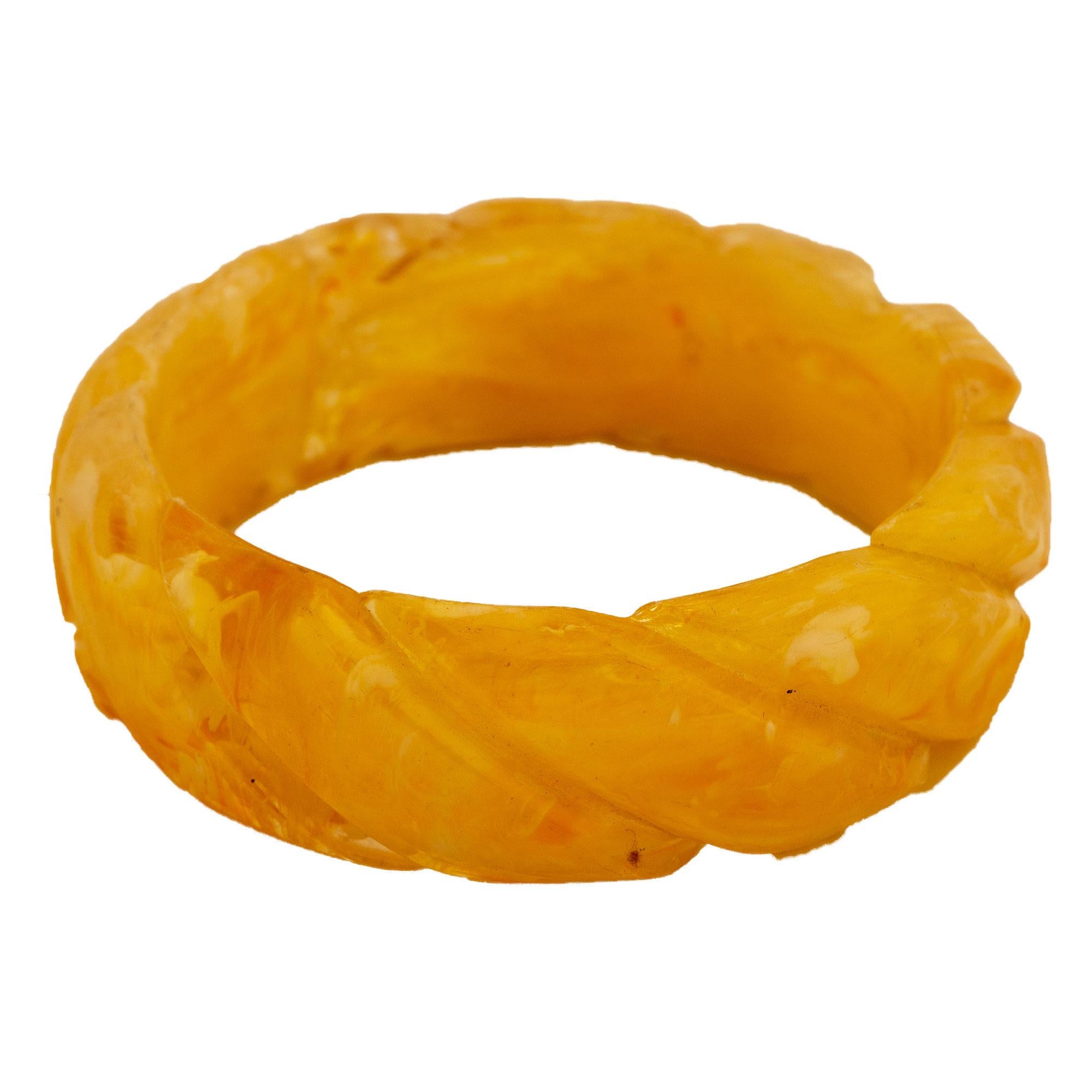 Bakelite bangle with carved diagonal braid shape, transparent and honey color.
Flattering bangle in the colors of early summer, rape honey and and translucency meet here. The elaborated shape of the braid pattern emphasizes the summer grace of this