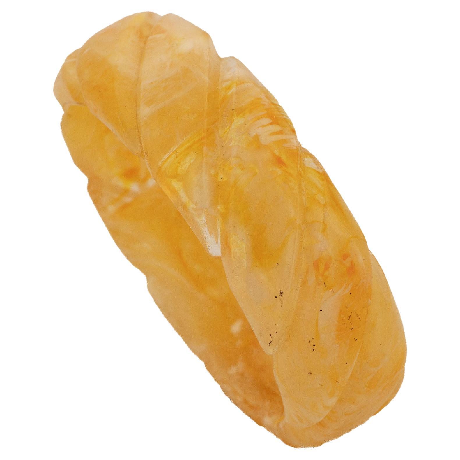 Bakelite bangle with carved diagonal braid shape, transparent and honey color.