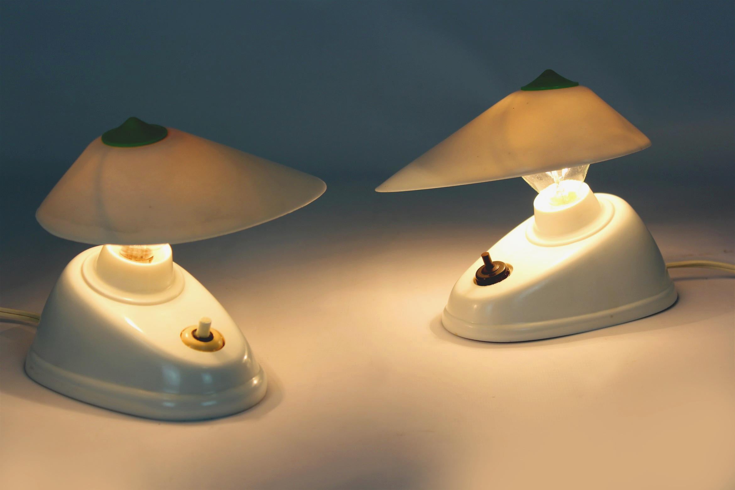 
A set of two bakelite table lamps in the Bauhaus style, produced in Czechoslovakia in the 1940s. Asymmetrical form, adjustable angle of the lampshade. The lamps have a visible model designation (11641) and the manufacturer's logo (ESC).
Preserved