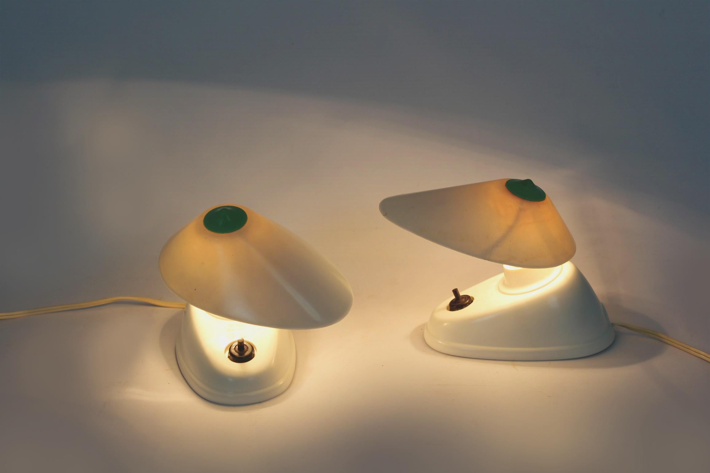 
A set of two bakelite table lamps in the Bauhaus style, produced in Czechoslovakia in the 1940s. Asymmetrical form, adjustable angle of the lampshade. The lamps have a visible model designation (11641) and the manufacturer's logo (ESC).
Preserved