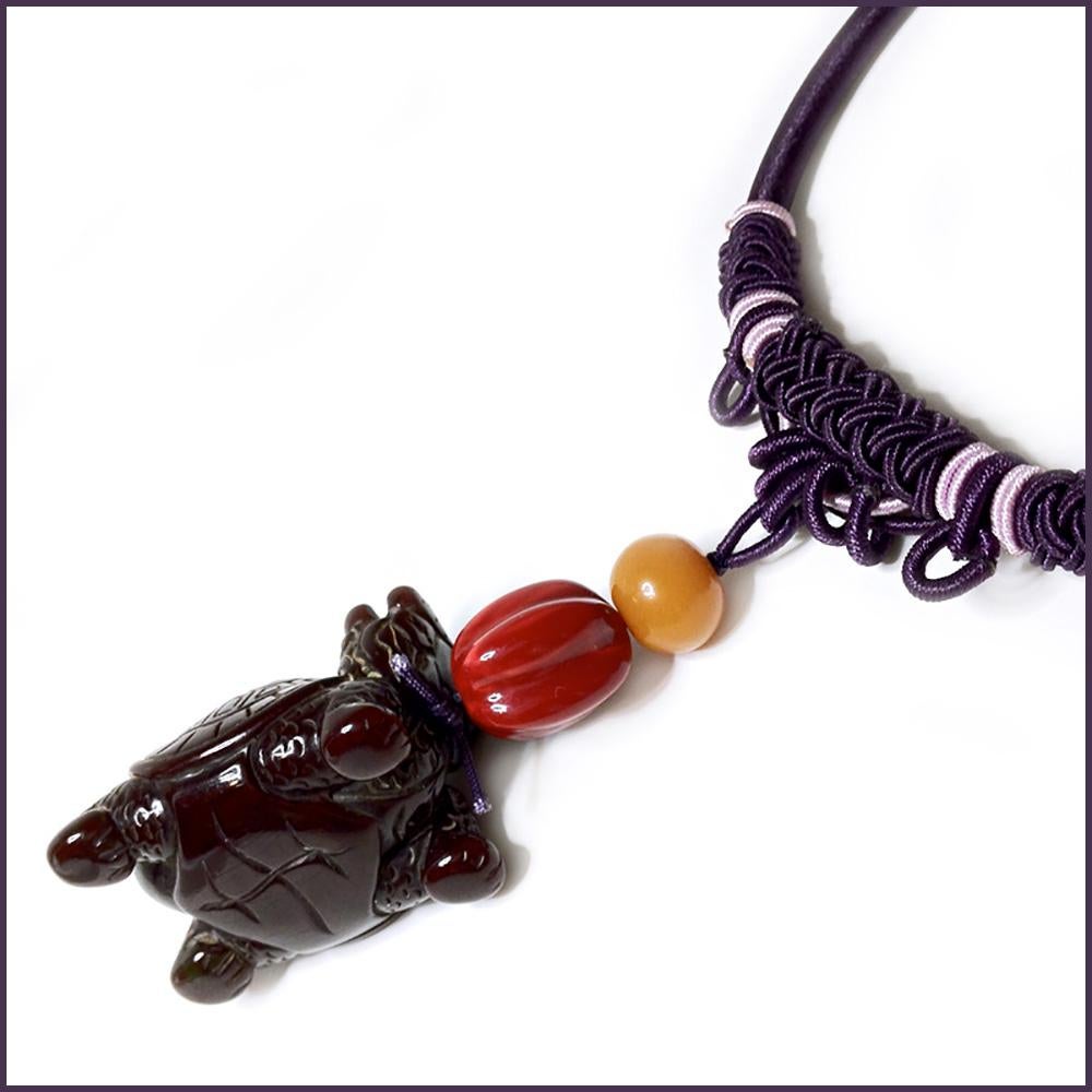 This is a bakelite Bixi silk collar/necklace. We created this one-of-the-kind fun piece with a deep purple turtle body with dragon head creature hung with a red melon shaped bead and an orange round bead as pendant. The purple silk wrapped collar