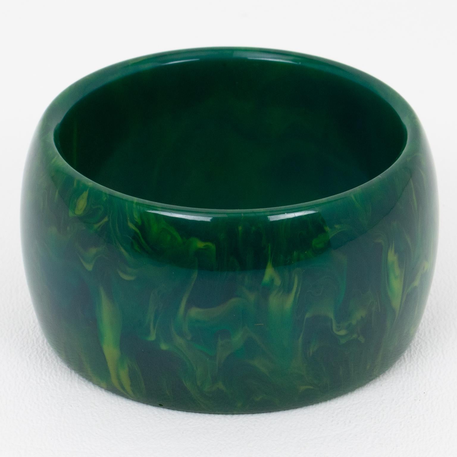 Ce magnifique bracelet en bakélite de marbre bleu-lune présente une forme large et massive en forme de dôme avec un ton de marbre bleu intense avec des nuages verts et blancs tourbillonnants. 
Dimensions : diamètre intérieur : 6,3 cm - diamètre