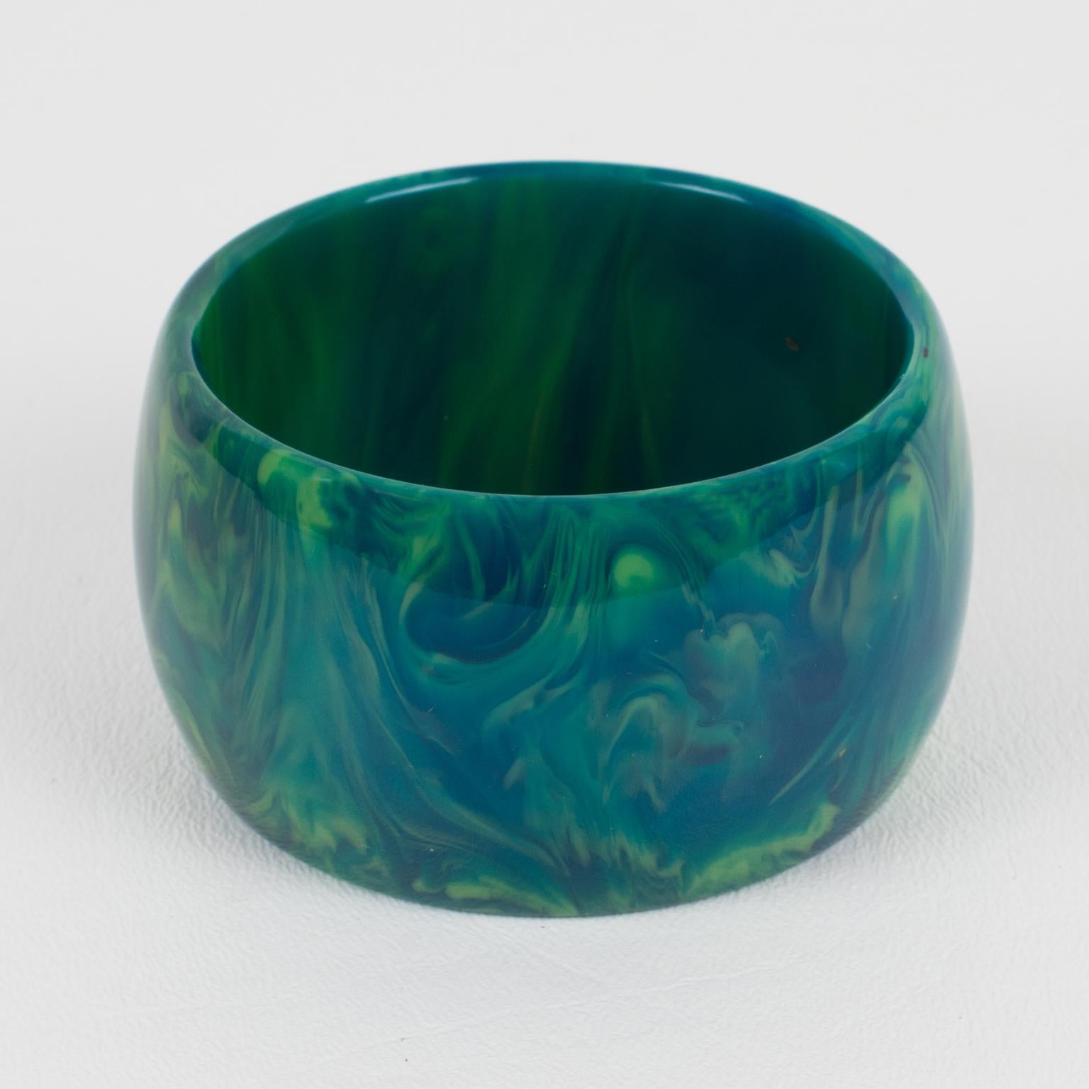 Gorgeous oversized blue-moon marble Bakelite bracelet bangle. Chunky wide domed shape. Intense blue marble tone with green and white cloudy swirling. 
Measurements: Inside across is 2.50 in. diameter (6.3 cm) - outside across is 3.07 in. diameter
