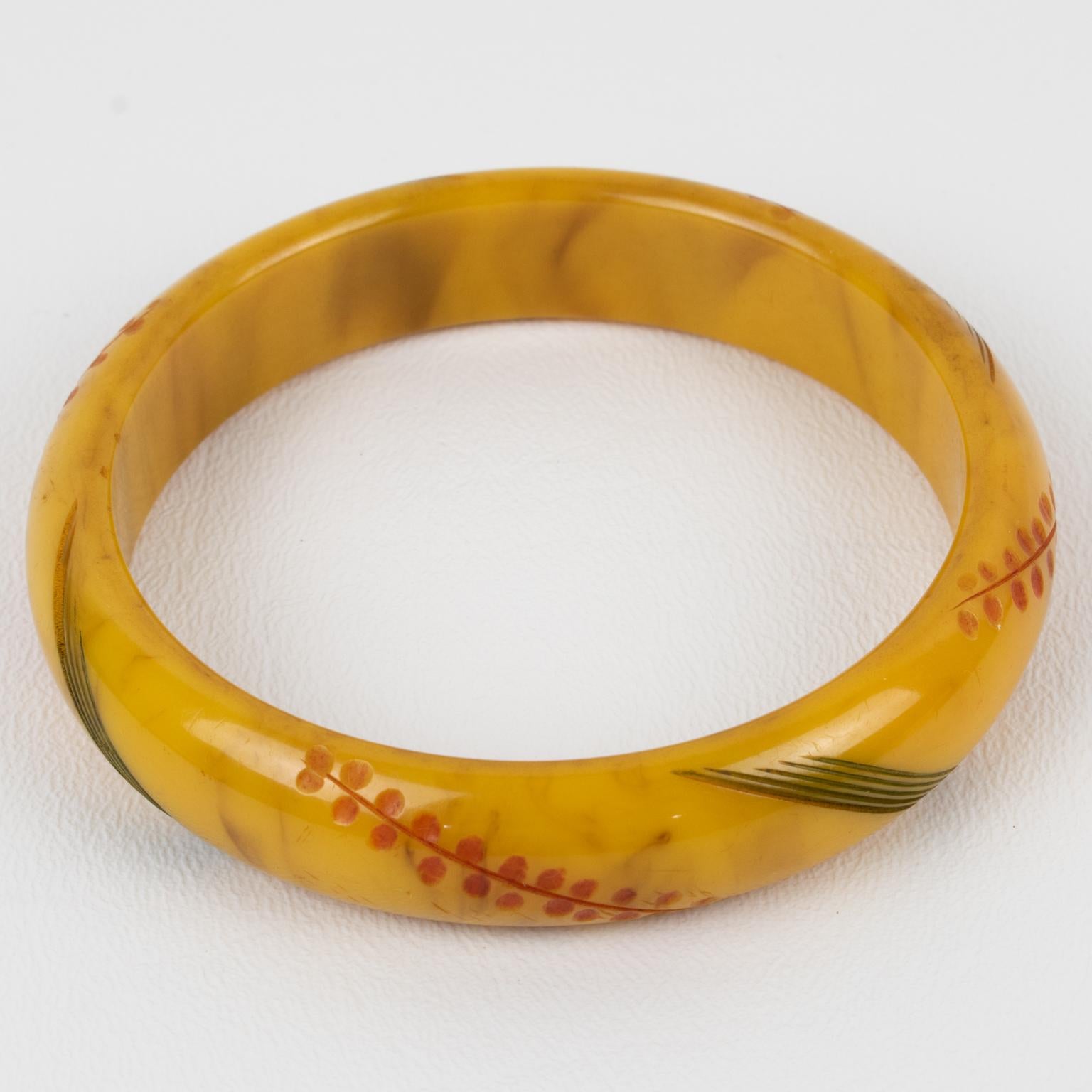 Elegant Bakelite bracelet bangle. Chunky domed shape with stylized floral and geometric carving, all around, and contrasting colors. The bangle color has an intense yellow banana color with toffee brown swirling (also called banana brown.) The