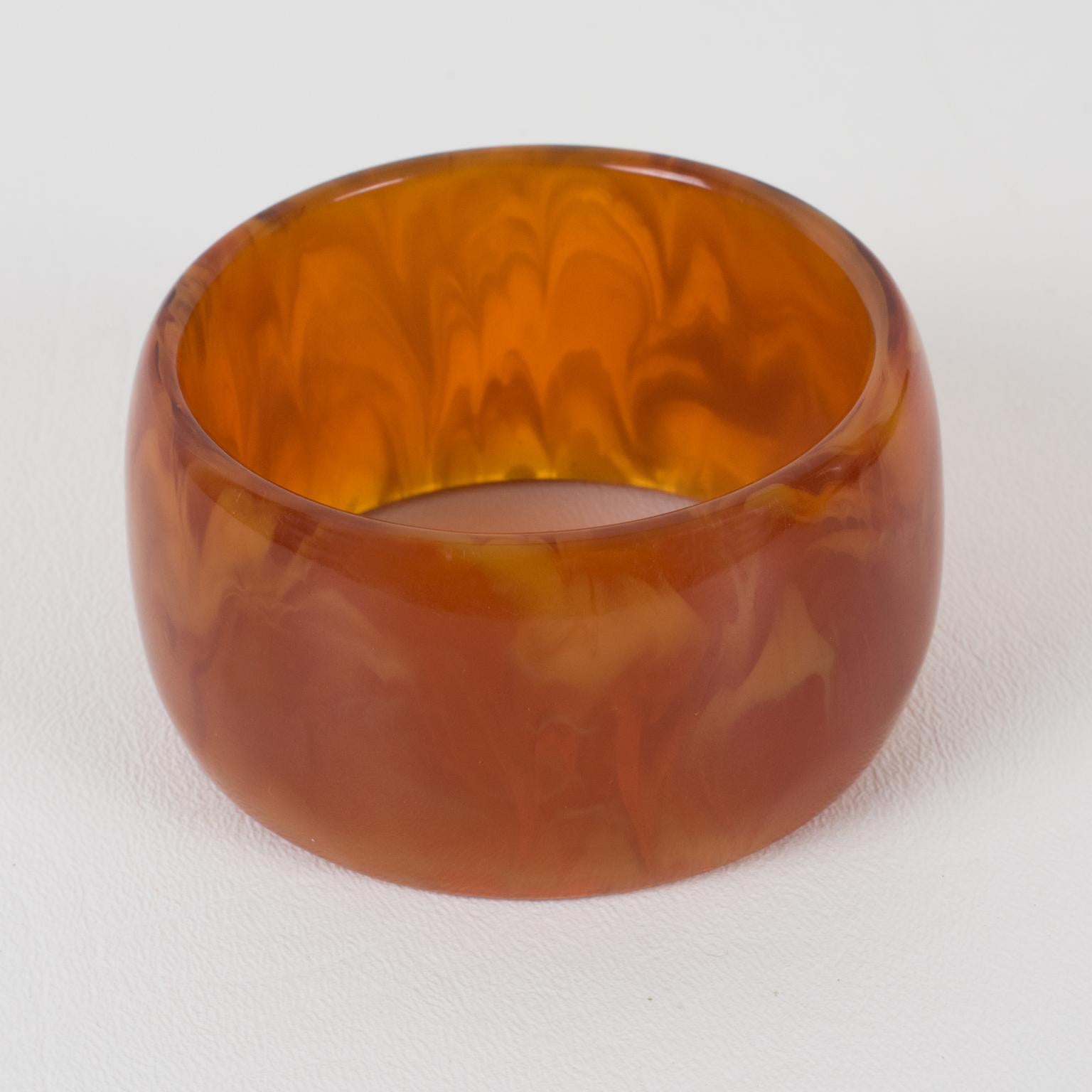 Questo delizioso bracciale bachelite in marmo rosso tè ambrato è caratterizzato da una forma a cupola larga e sovradimensionata. L'intenso tono marmoreo del tè rosso ha una trasparenza e dei vortici color miele e ambra. 
Misure: Il diametro interno