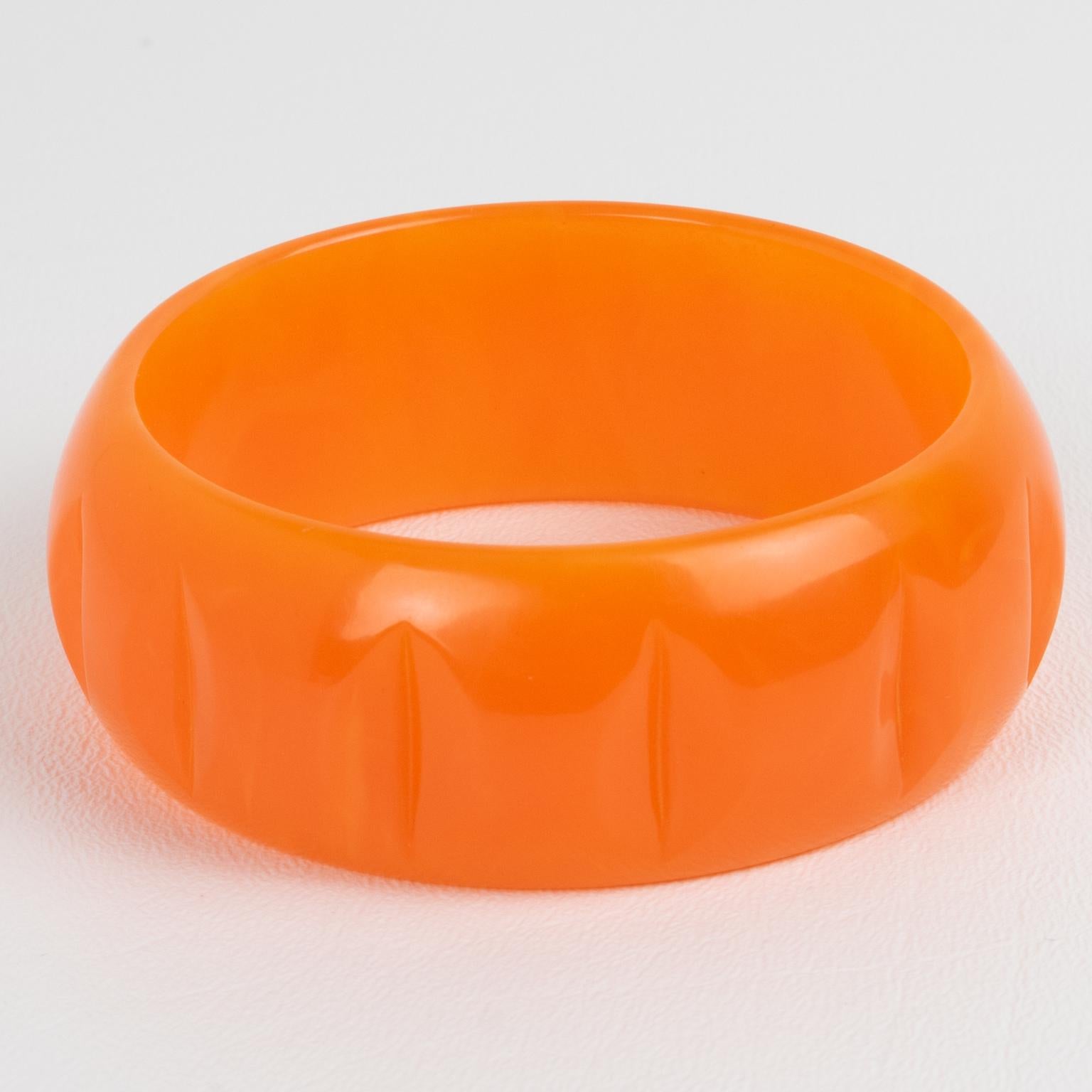 This is a lovely orange tangerine marble Bakelite carved bracelet bangle. It features a chunky domed shape with a carved design all around. The color is an intense sunny orange tone with lighter milky swirling.
Measurements: Inside across 2.57 in