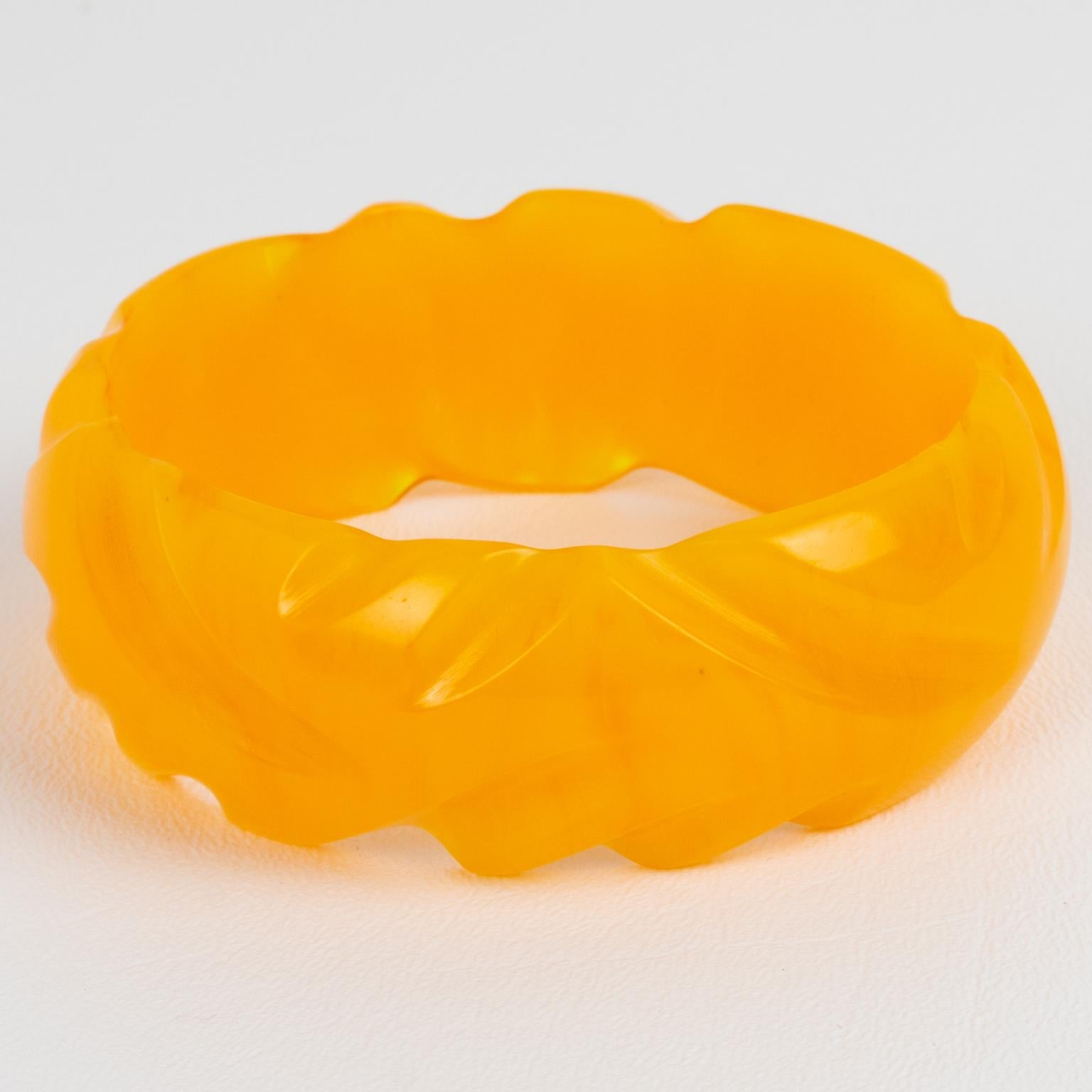 This is a lovely yellow marigold marble Bakelite carved bracelet bangle. It features a chunky domed shape with a carved design all around. The color is a sunny intense warm yellow tone with lighter milky swirling.
Good condition, with a tiny air