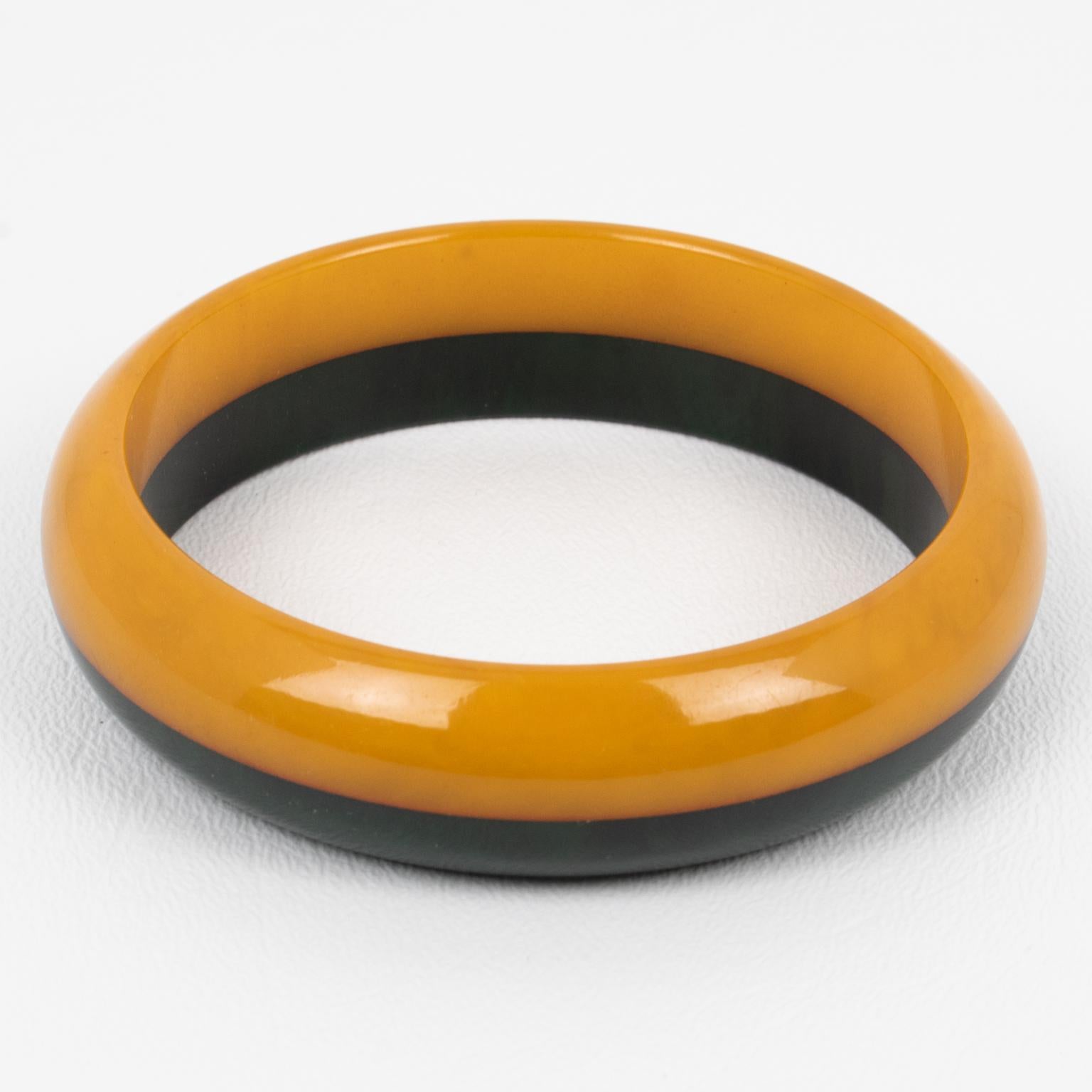 This is a lovely bi-color marble Bakelite laminated bracelet bangle. The piece features a chunky domed shape with a bi-layer design. The colors are a sunny orange butterscotch marble tone and dark green marble.
Measurements: Inside across 2.63 in