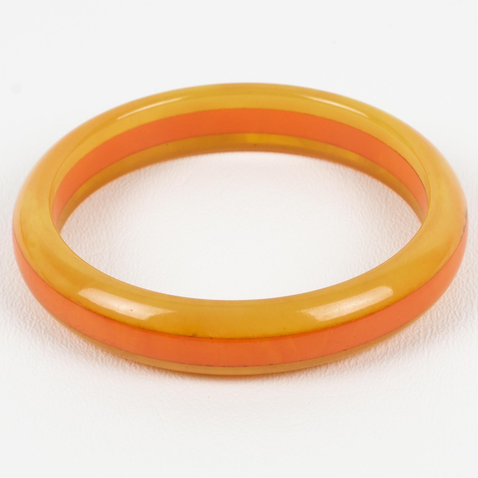 This is a lovely bi-color marble Bakelite laminated bracelet bangle. It features a chunky domed shape with a multi-layer design. The colors are a sunny intense warm orange tone with lighter milky swirling combined with a warm yellow curry marble