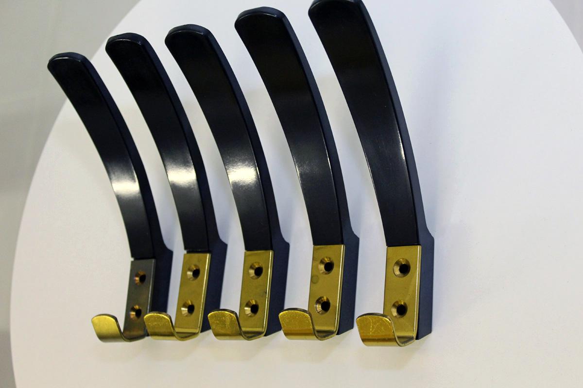 This set of 9 coat hooks is made of Bakelite with solid brass details. It is marked with KM AUSTRIA.