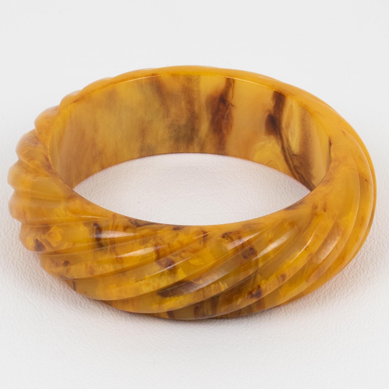 This incredible Mississippi Swamp marble Bakelite carved bracelet bangle features a chunky domed shape with deep geometric carving. Its bold and beautiful design displays stripes all around and a thick-walled pattern. The butterscotch marbled color