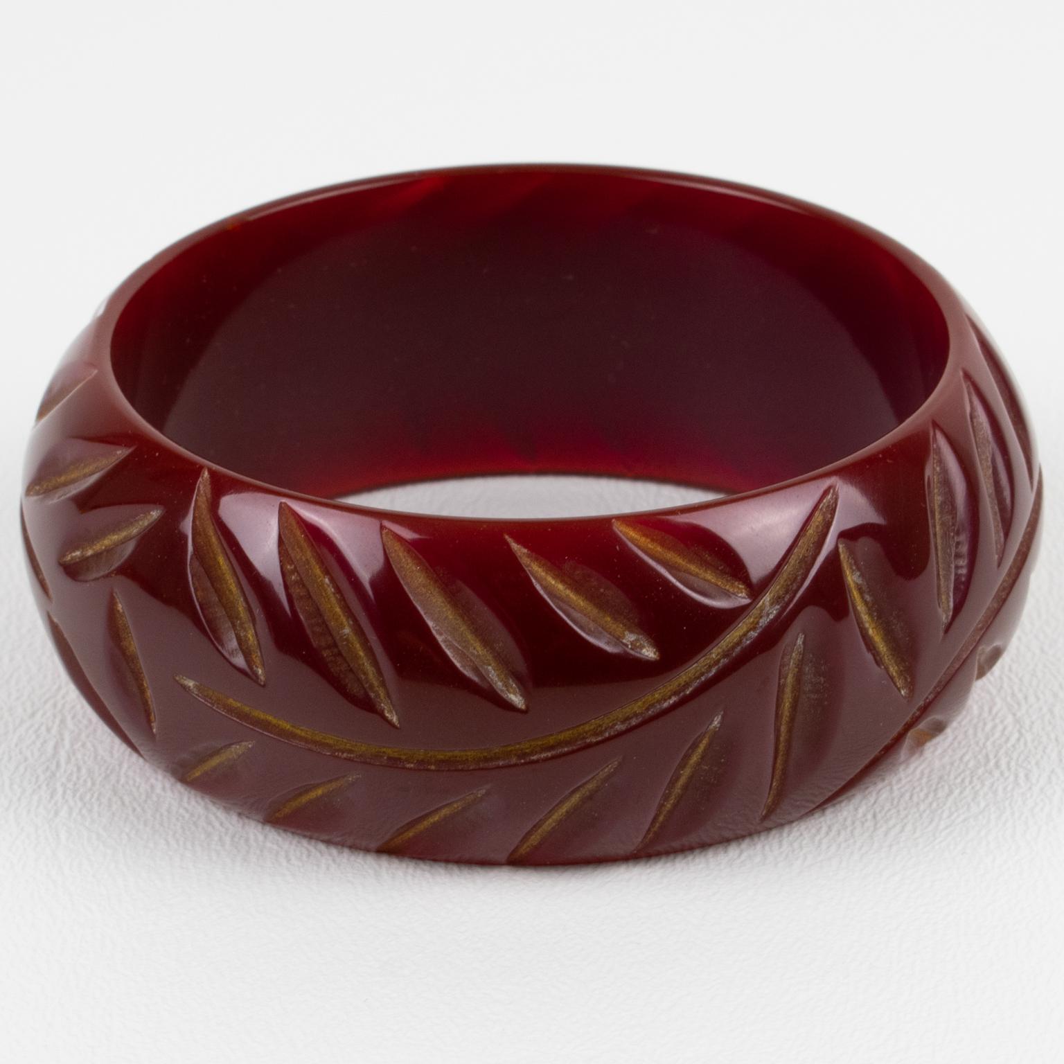 This is a fabulous dark cranberry red Bakelite bracelet bangle. It features a chunky domed shape with geometric and deeply carved designs all around. The color is an intense dark red plain tone with a light purple overtone. 
Measurements: Inside