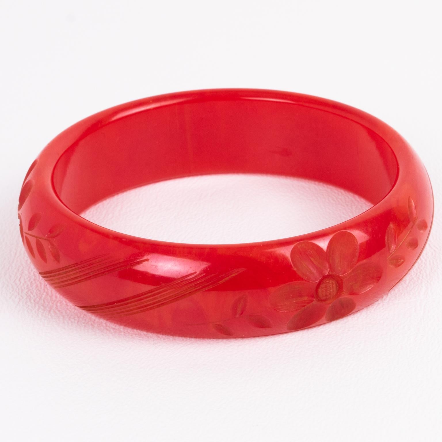 This is a gorgeous magenta-red marble Bakelite carved bracelet bangle. It features a spacer domed shape with a deep geometric and floral carving. The color is an intense bright red tone with light orange cloudy swirling. 
Measurements: Inside across