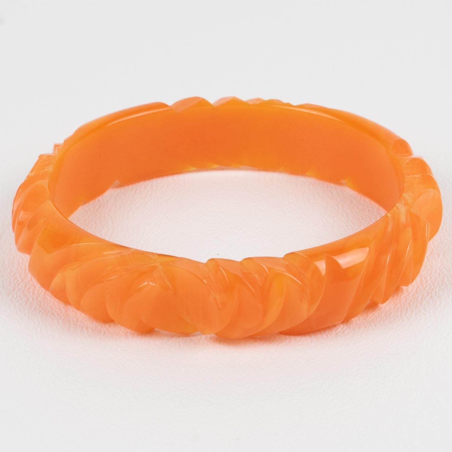 This is a lovely milky orange papaya Bakelite carved bracelet bangle. It features a spacer domed shape with deep geometric carving all around. The color is an intense orange papaya tone with milky swirling. 
Measurements: Inside across is 2.57 in