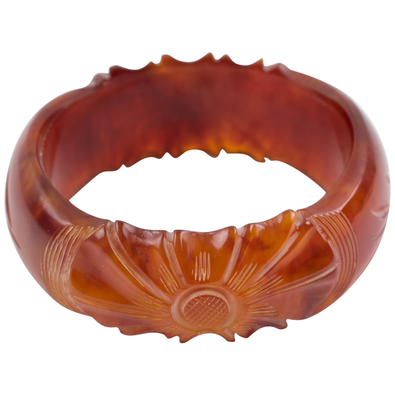 This stunning red tea marble Bakelite carved bracelet bangle features a chunky domed shape with deep floral carving. Its bold and beautiful design displays two large sculpted flowers with leaves in between and a thick-walled pattern. The