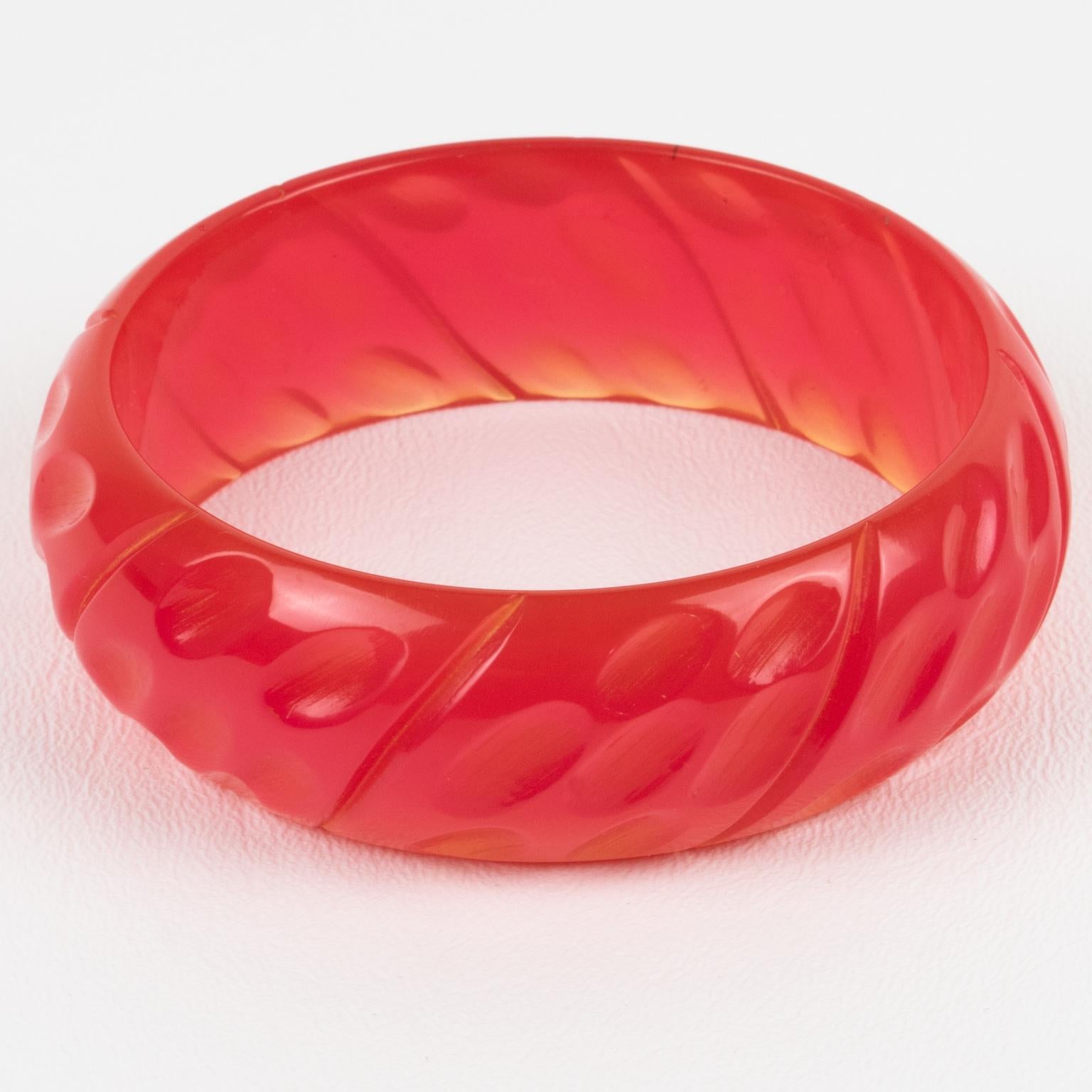 This is a spectacular hot pink bubblegum Bakelite bracelet bangle. It features a chunky domed shape with geometric and deeply carved designs all around. The color is an intense hot pink plain tone with complete translucency. 
Measurements: Inside