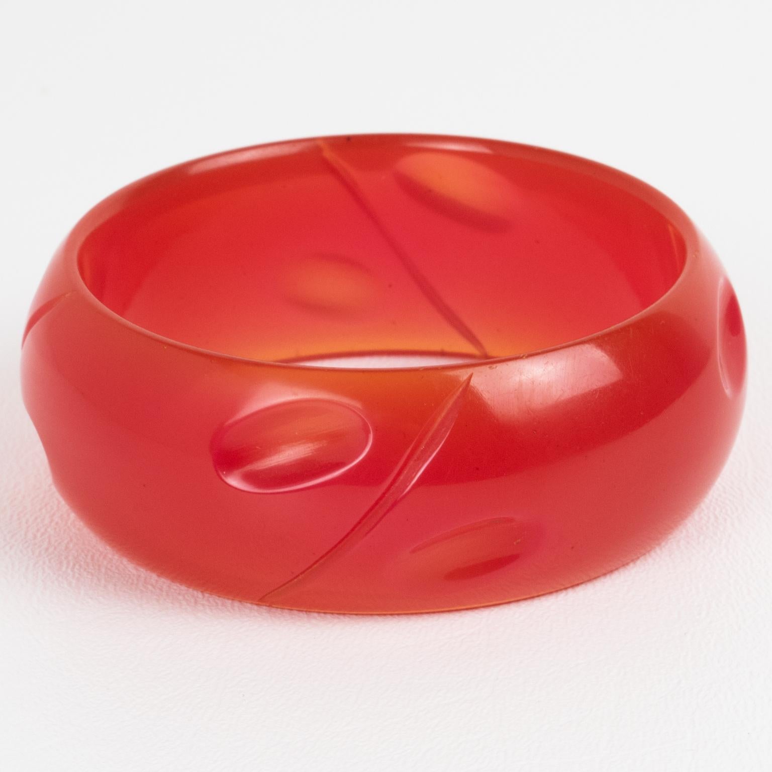 This is a lovely hot pink watermelon Bakelite bracelet bangle. It features a chunky domed shape with a geometric and deeply carved design. The color is an intense neon pink plain tone, completely translucent. 
Measurements: Inside across is 2.63 in