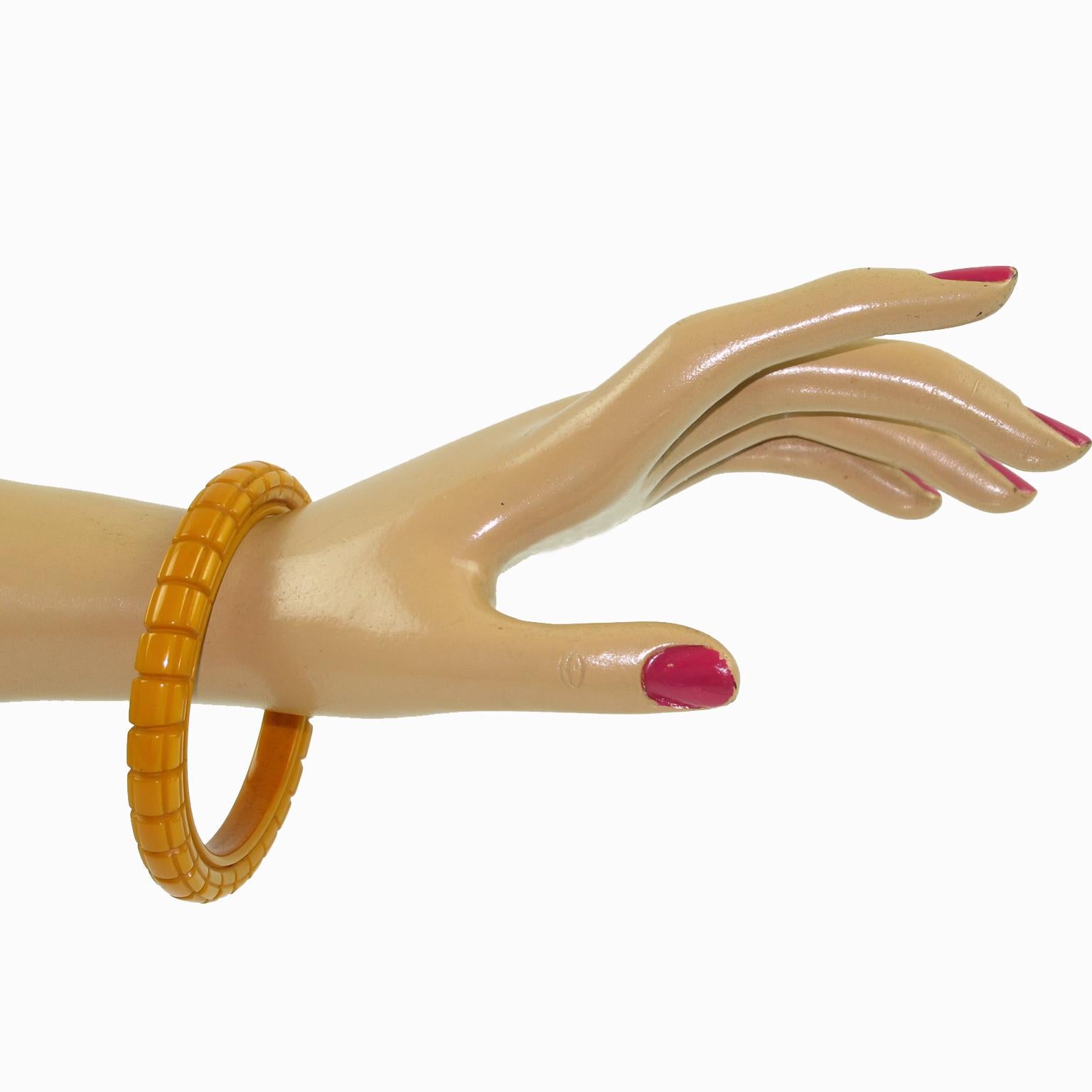 This amazing butterscotch Bakelite carved bracelet bangle features a spacer-domed shape with a deep geometric carving all around it and a thick wall. The piece boasts an intense yellow butterscotch color. 
Measurements: Inside across is 2.63 in