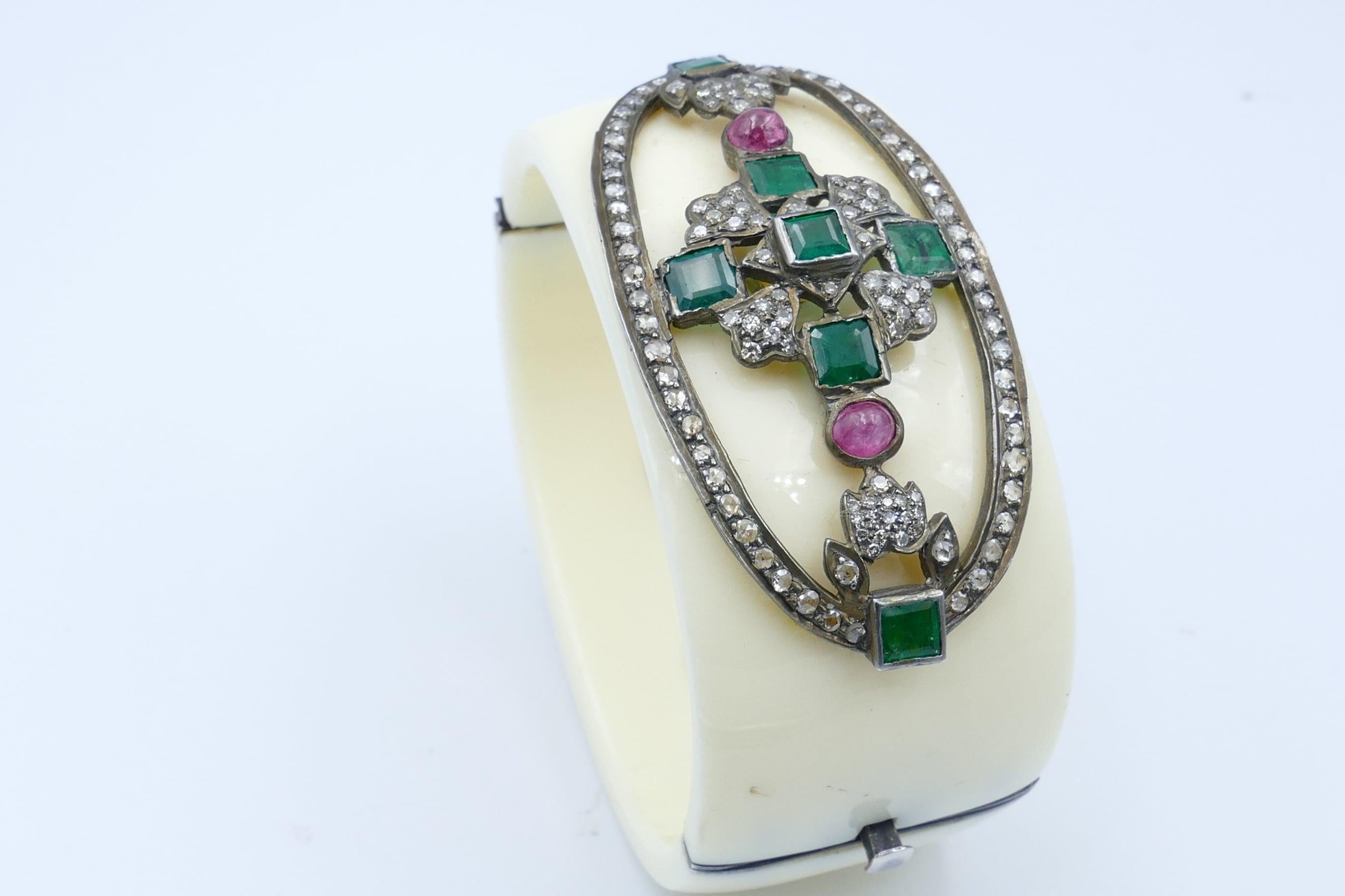 Such a different and hard to find Bangle consisting of 7 bluish-green Emeralds, 2 pretty pink cabochon cut Sapphires with a further 124 round brilliant single cut Diamonds.
It all makes up such a pretty, pretty top pattern.
The Bangle is a good