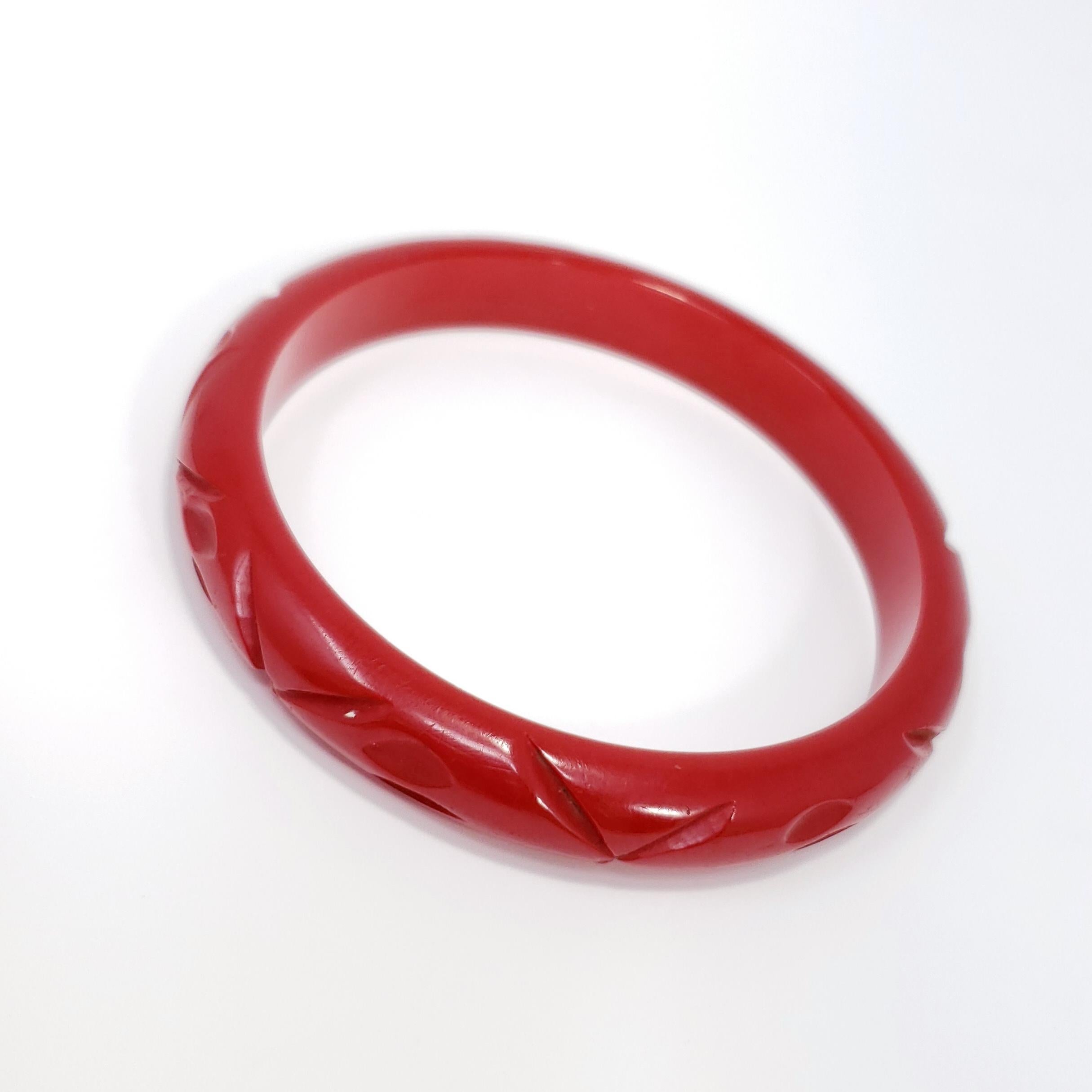 Un bracelet bangle en bakélite sculpté vintage en rouge ambre cerise. 

Merveilleux état.

Diamètre intérieur : 6,45 cm
