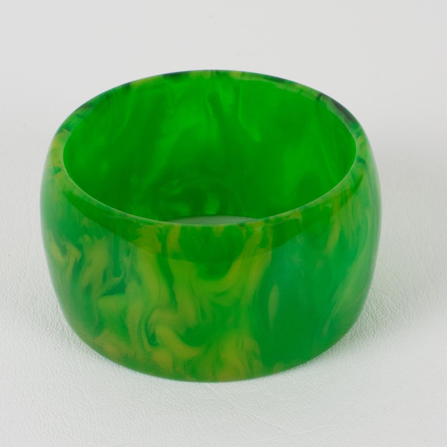 This gorgeous oversized green grass marble Bakelite bracelet bangle features a chunky wide domed shape. The piece boasts an intense green marble tone with yellow and white cloudy swirling and translucency. 
Measurements: Inside across is 2.57 in