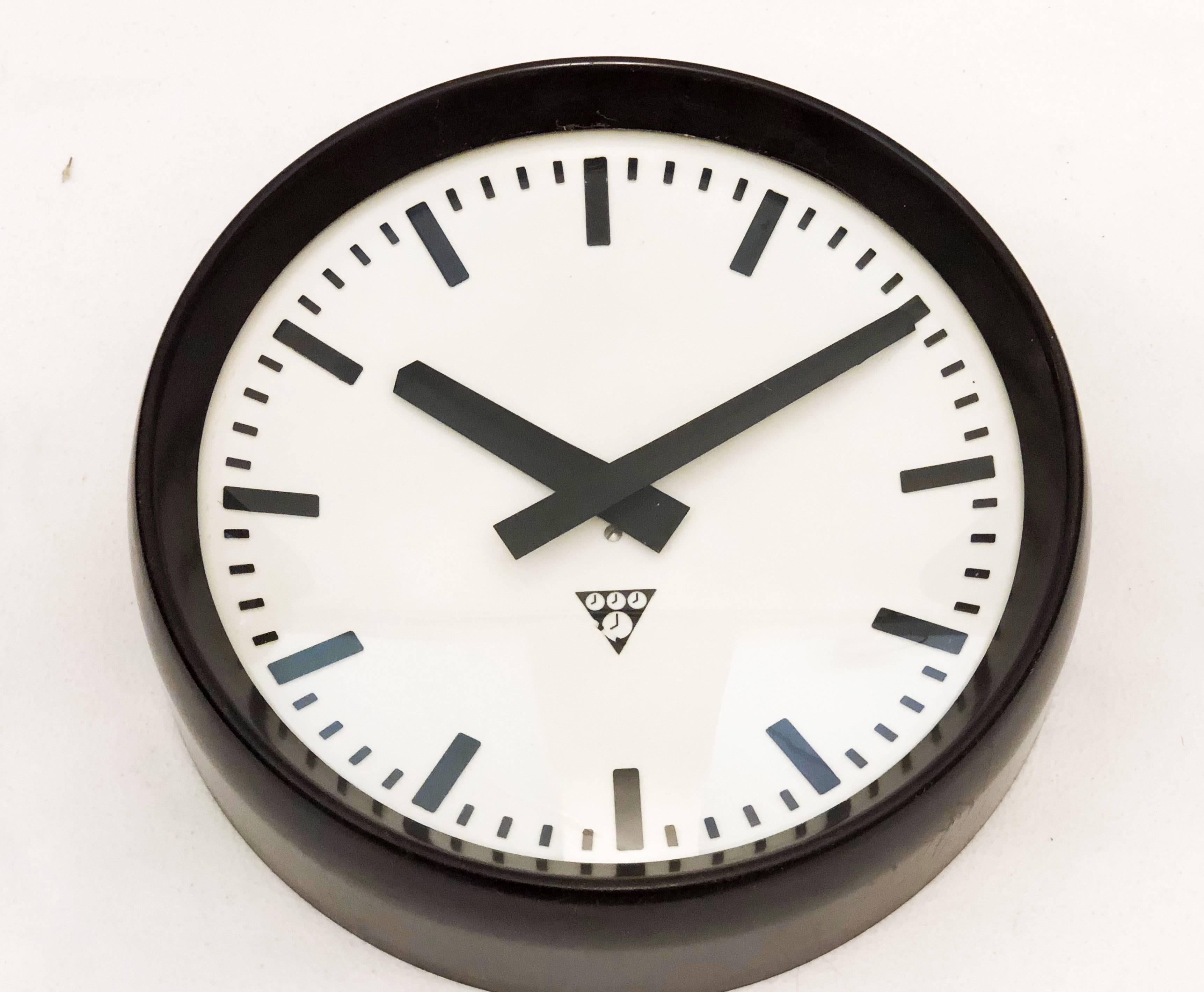 Industrial wall clock Pragotron. Frame made of bakelite. The clock face is covered with glass. Formerly a slave clock, it is now fitted with a modern quartz movement with an AA-battery. Delivery time about 2 weeks.