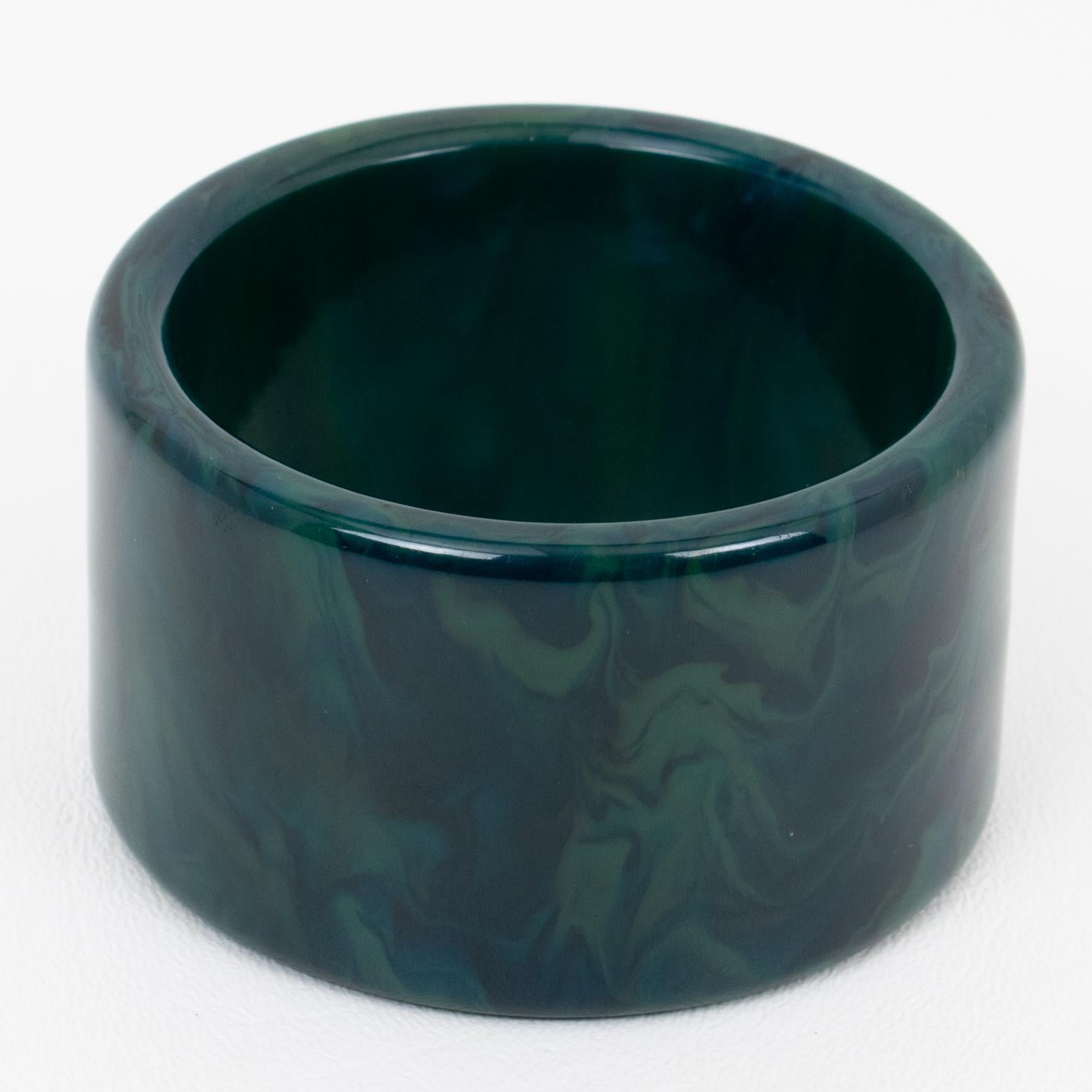 Questo superbo braccialetto in marmo blu tempestoso di bachelite presenta una forma a fette larghe XL con un intenso colore blu marino, verde e blu chiaro. 
Misure: Il diametro interno è di 2,50 pollici (6,3 cm) - il diametro esterno è di 3 pollici