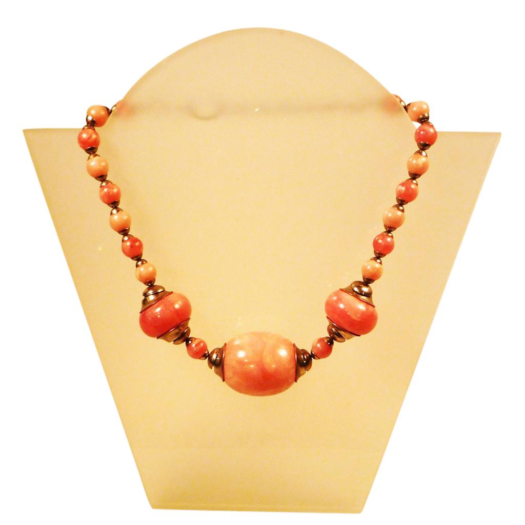 Bakelite necklace, Jakob Bengel, Idar-Oberstein, c. 1930

Collier of the famous jewellery manufacturer Jakob Bengel from Idar-Oberstein; pink coloured pearls from bakelite with streaks connected by chrome elements.
Size of the central ball: 3.8 x 3